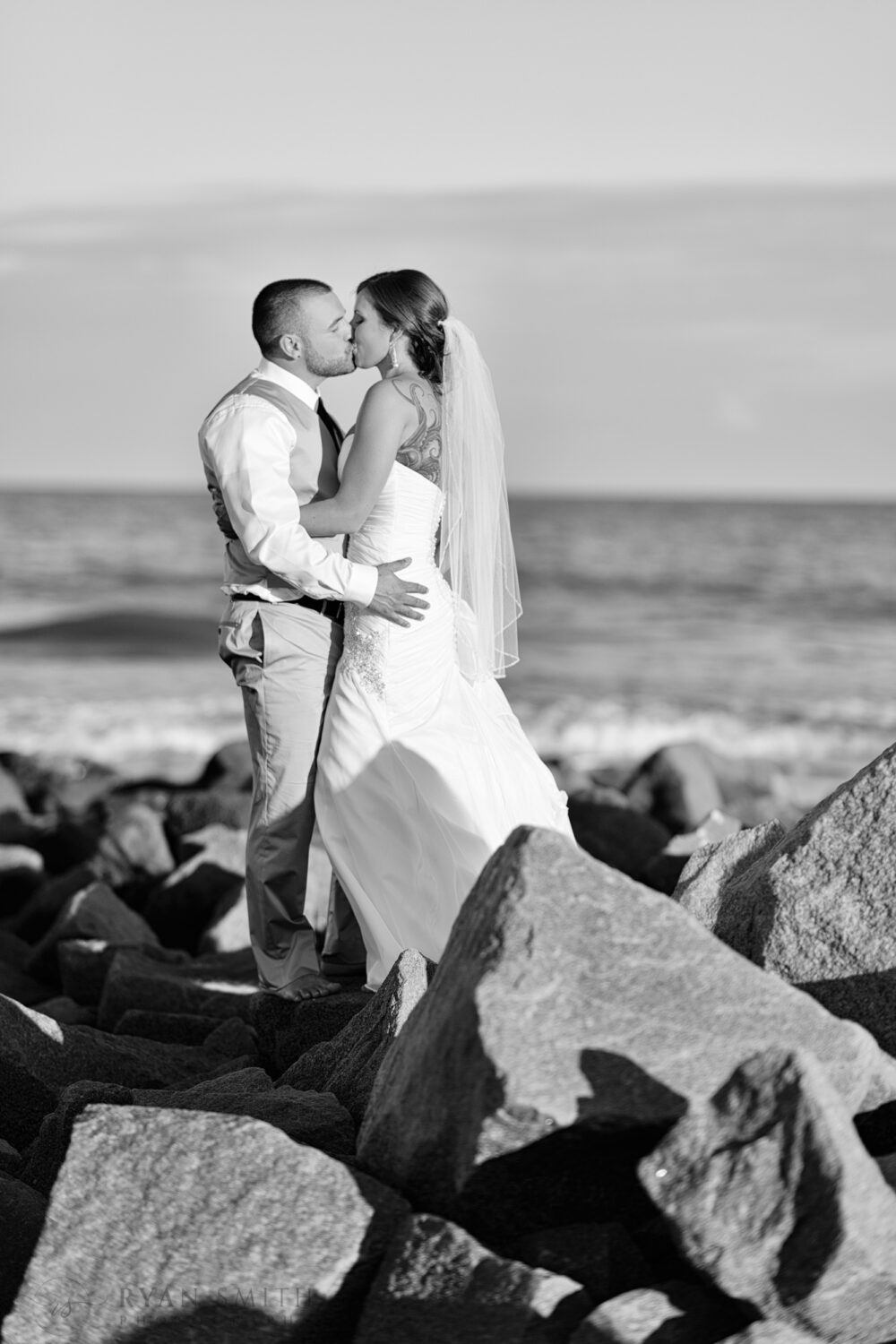 Portrait of wedding couple on a rock jetty - Garden City Beach