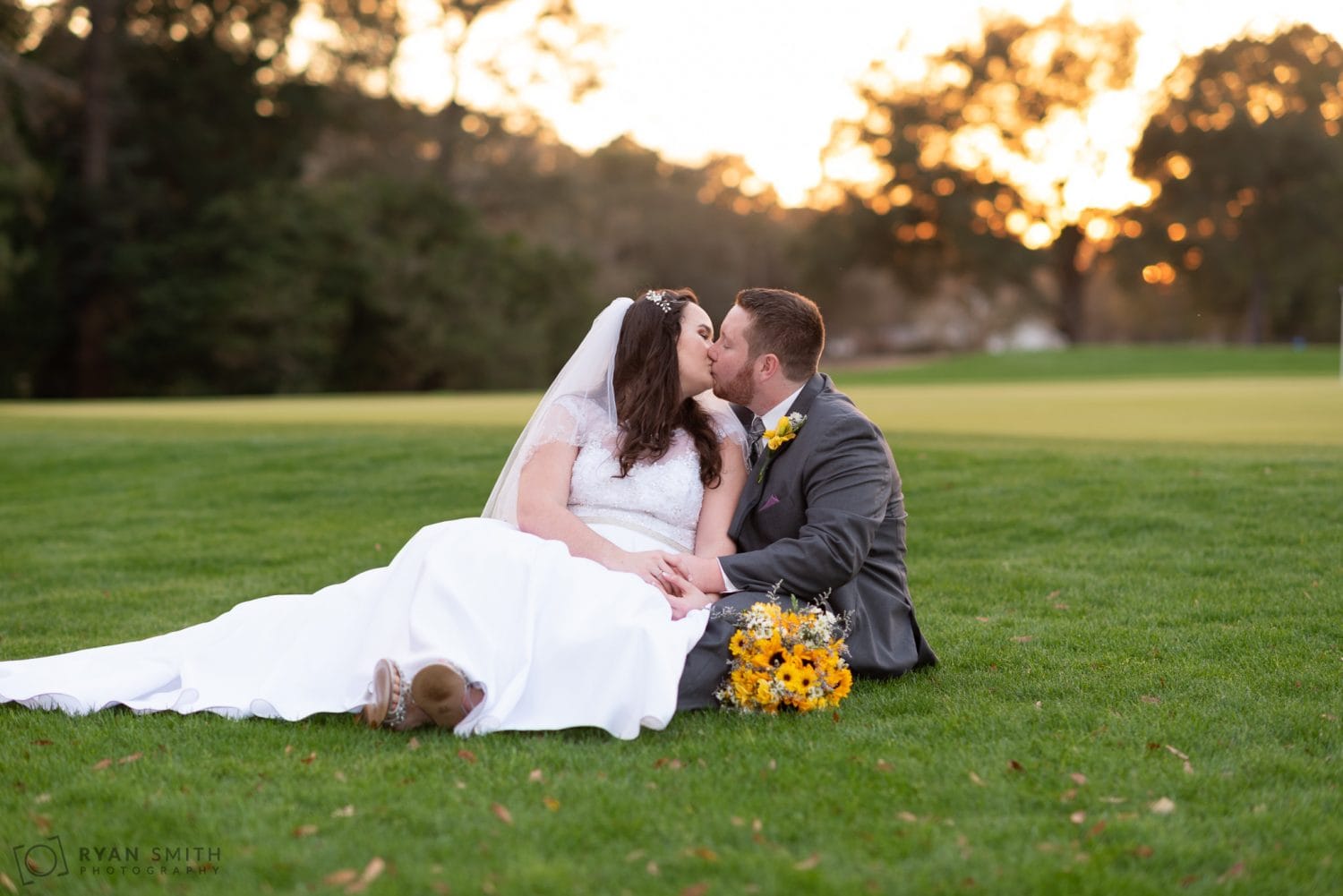 Bride and groom laying together on the golf course Litchfield Country Club