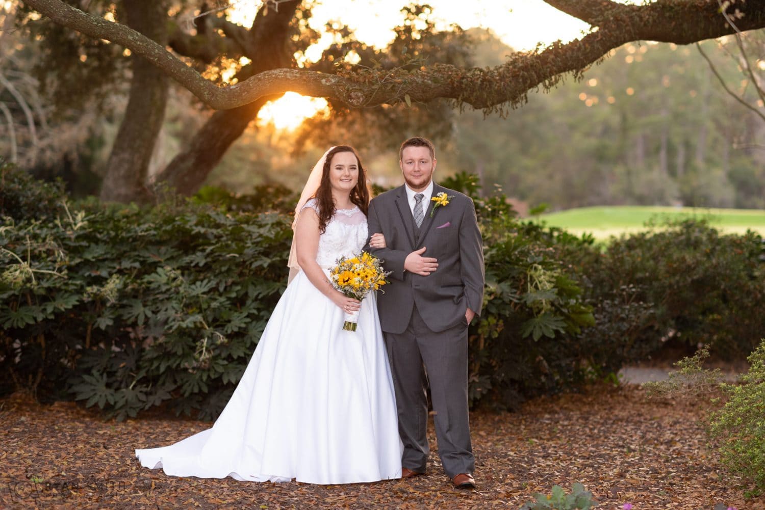 Bride with arm around the groom backlit by the sunset Litchfield Country Club