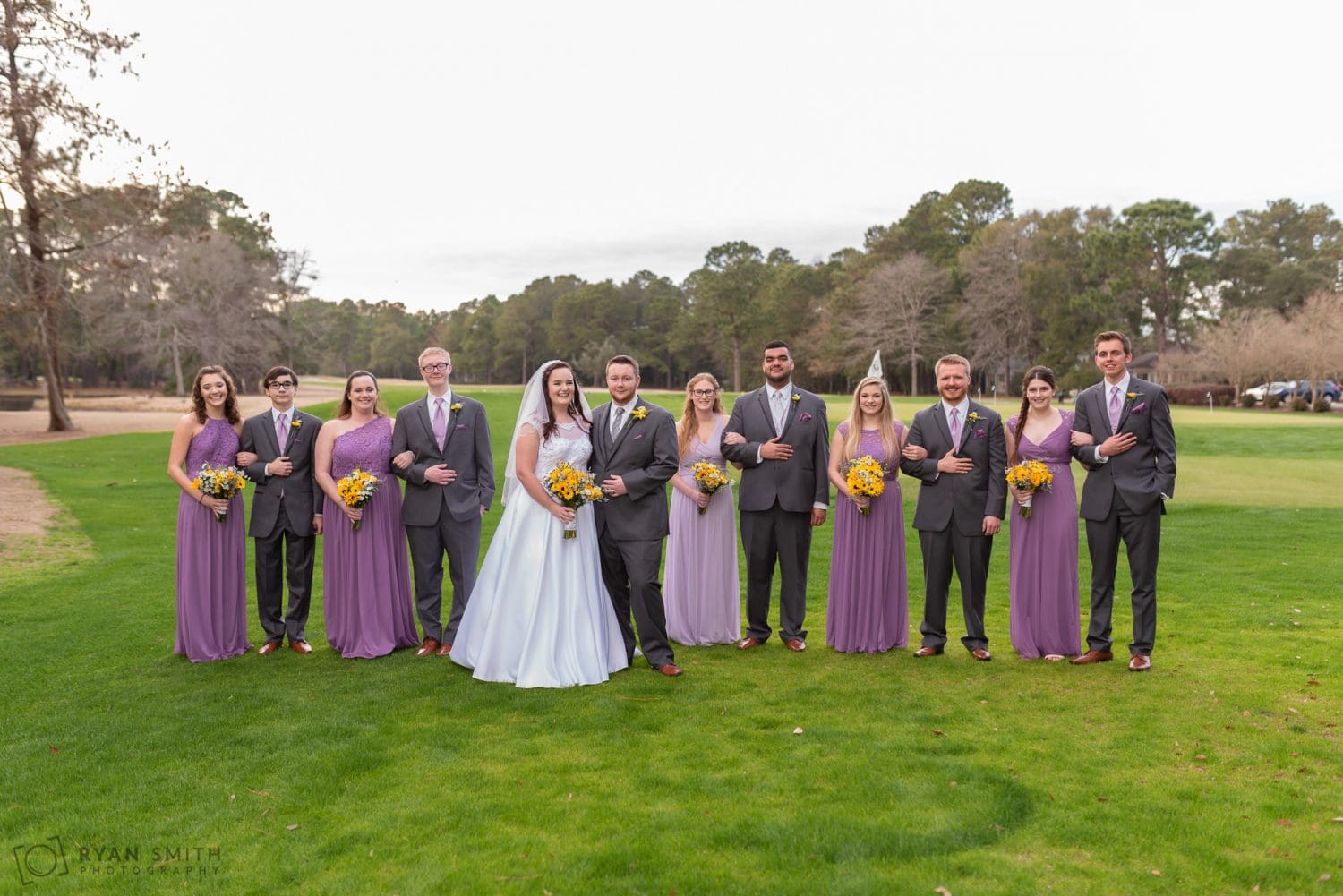 Bridesmaids and groomsmen standing together on the golf course Litchfield Country Club