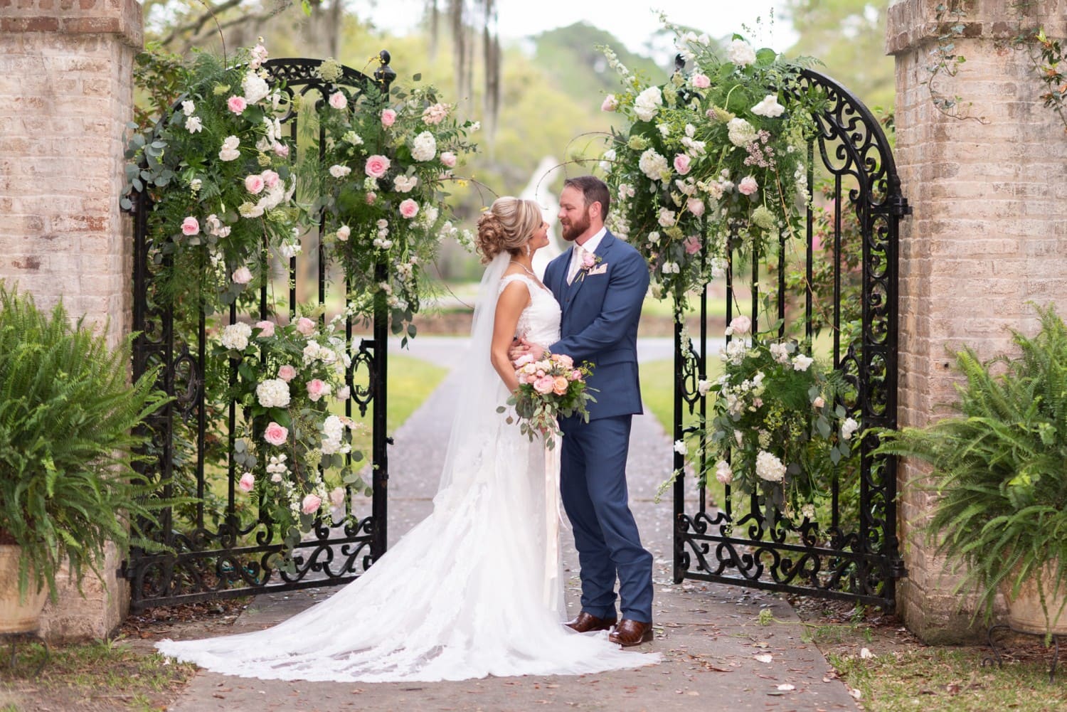 Bride and groom standing by the open gates - Brookgreen Gardens