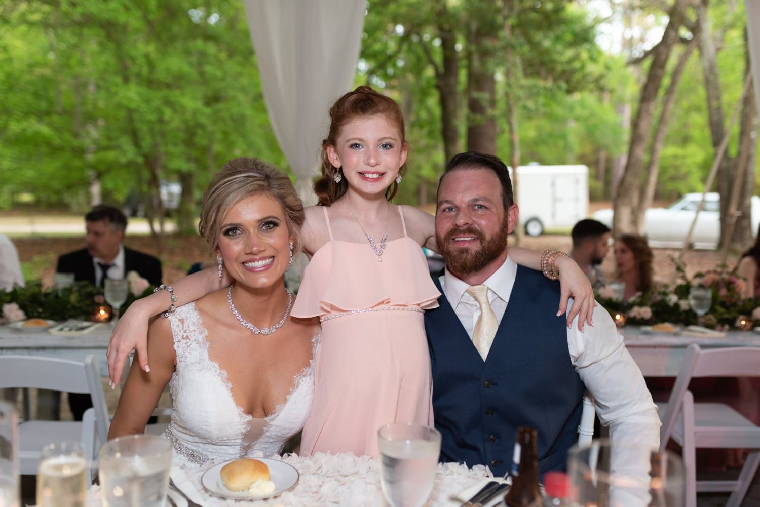 Bride and groom with daughter at table - Brookgreen Gardens