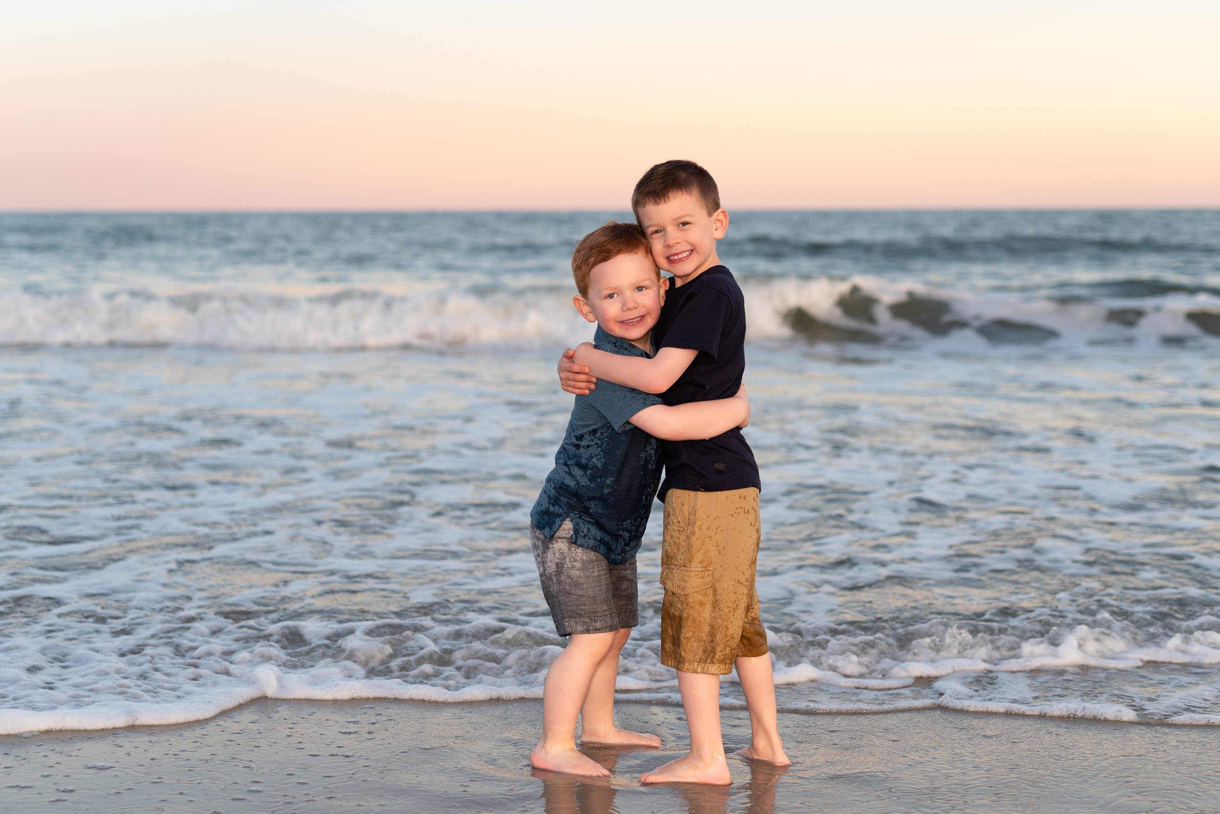 Brothers hugging by the ocean -