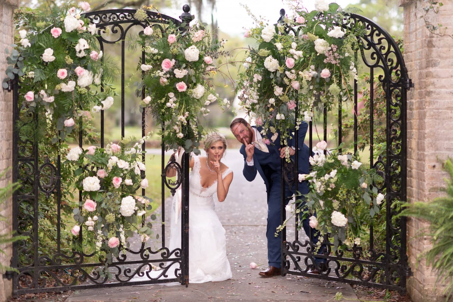 Groom and bride having fun by the gates - Brookgreen Gardens