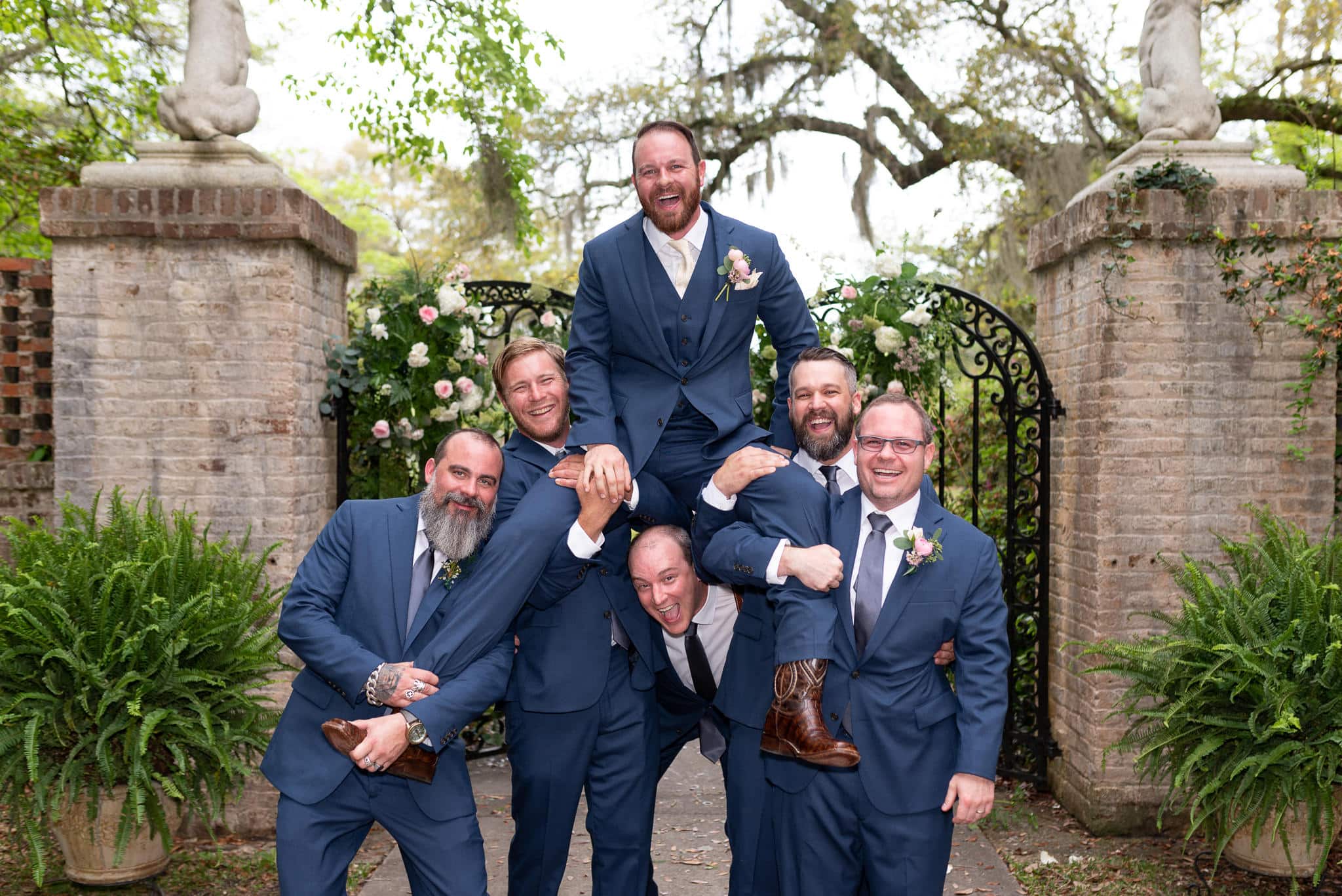 Groomsmen lifting up the groom by the gates - Brookgreen Gardens