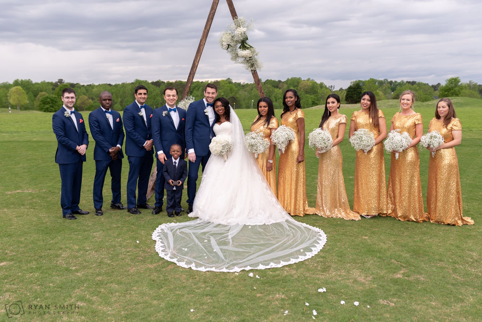 Bridal party in front of the wedding arch River Ridge Golf Club