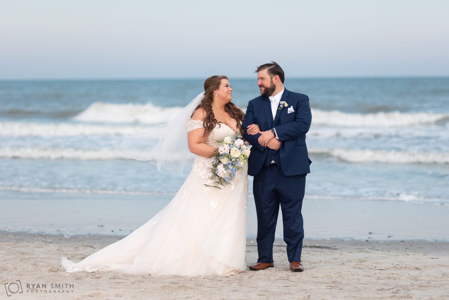 Bride and groom looking at each other in front of the ocean Grande Dunes Ocean Club