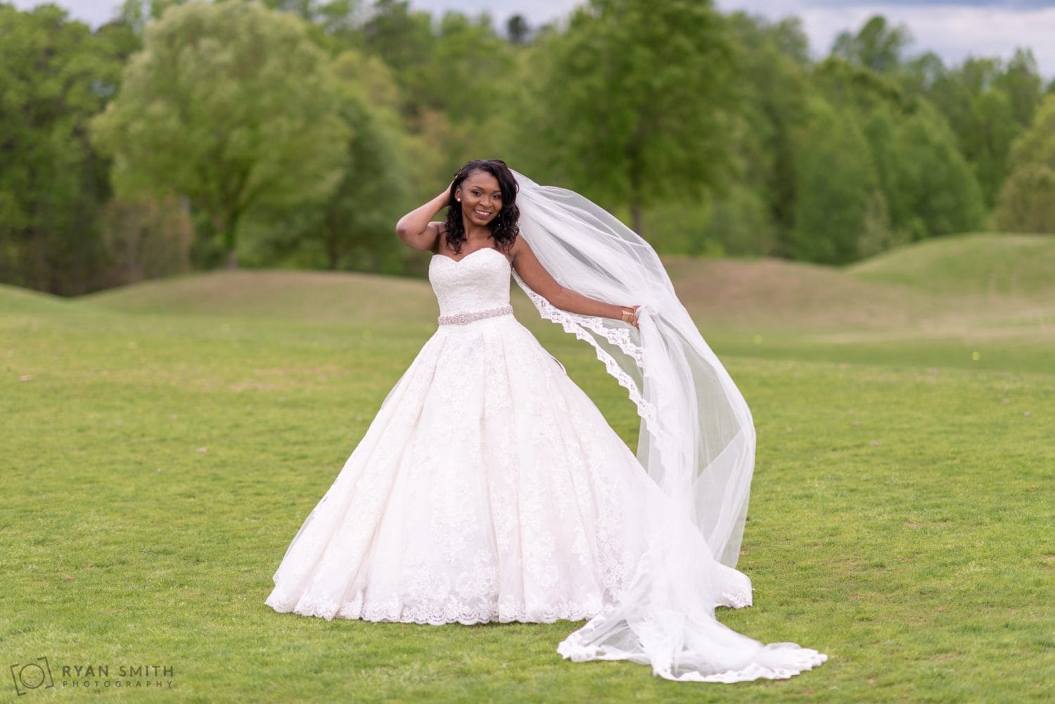 Bride holding her long veil River Ridge Golf Club