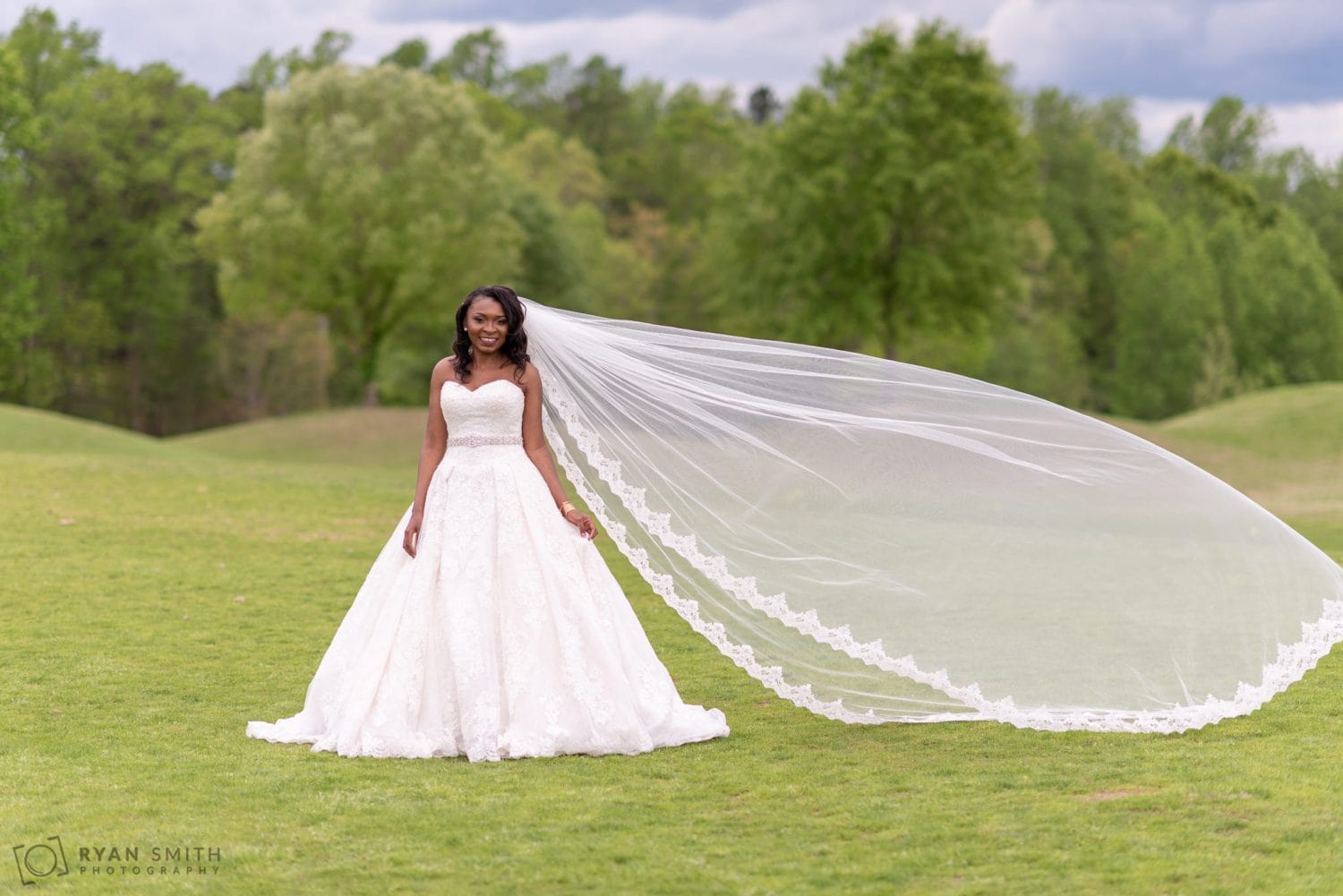 Bride with long veil blowing in the wind River Ridge Golf Club