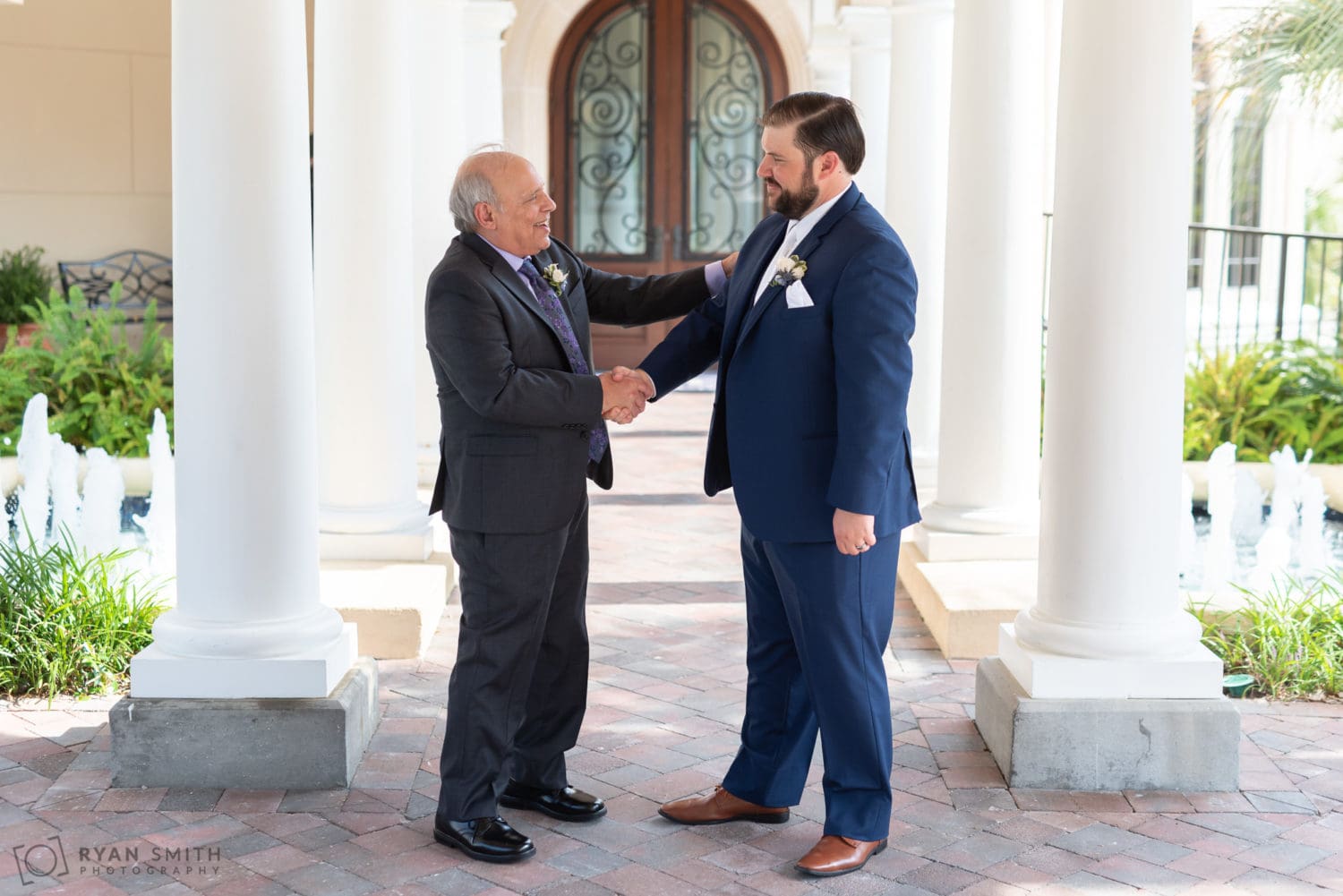 Groom shaking hands with his father Grande Dunes Ocean Club