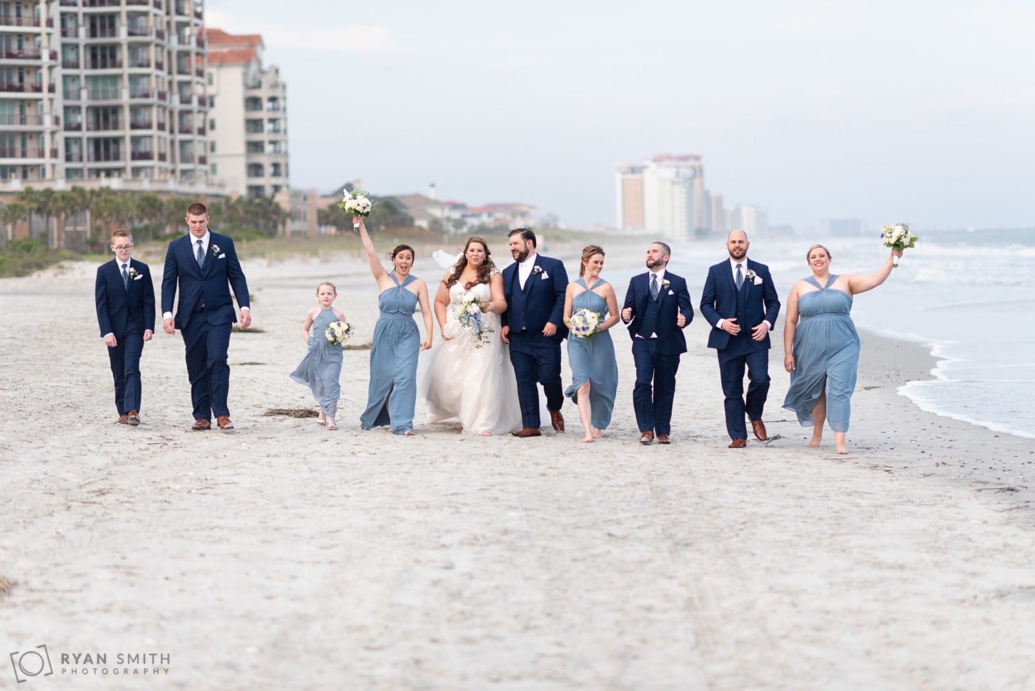 Wedding party walking down the beach Grande Dunes Ocean Club