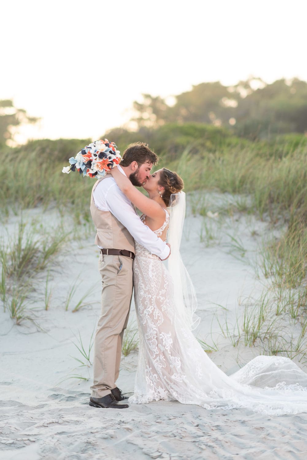Bride and groom kissing by the dunes Grande Dunes Ocean Club - Myrtle Beach