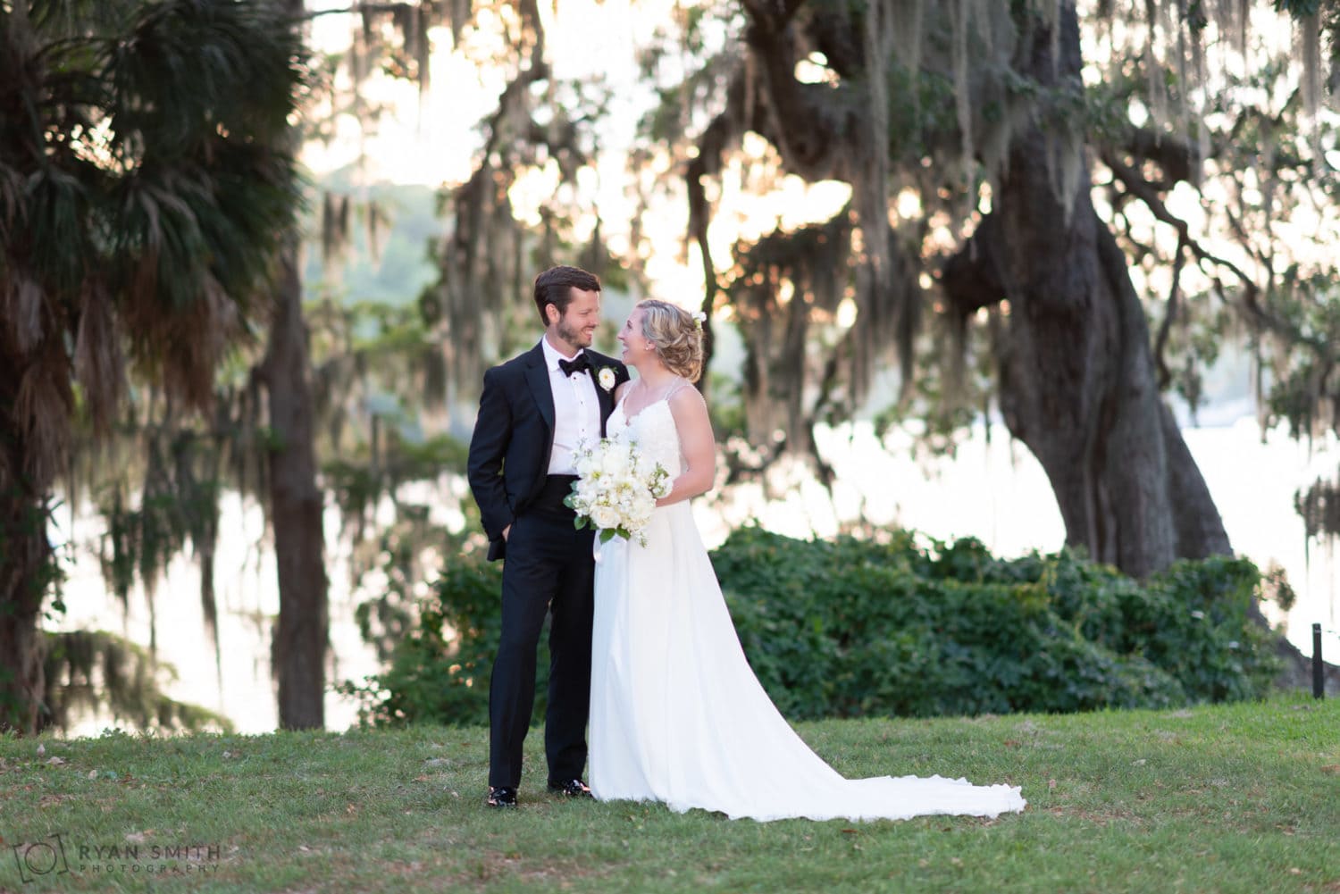 Bride and groom looking into each other eyes by the river Wachesaw Plantation