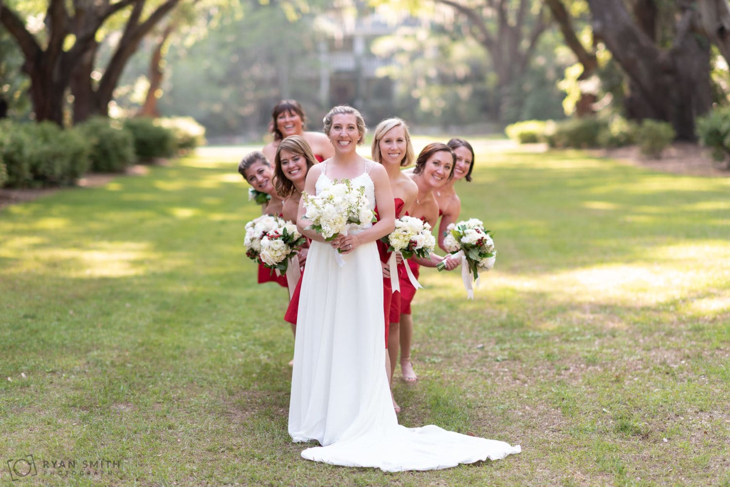 Bridesmaids peeking out from behind the bride Wachesaw Plantation
