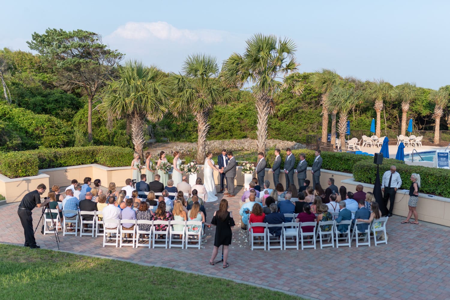 Wedding ceremony by the palm trees on the patio - Grande Dunes Ocean Club - Myrtle Beach