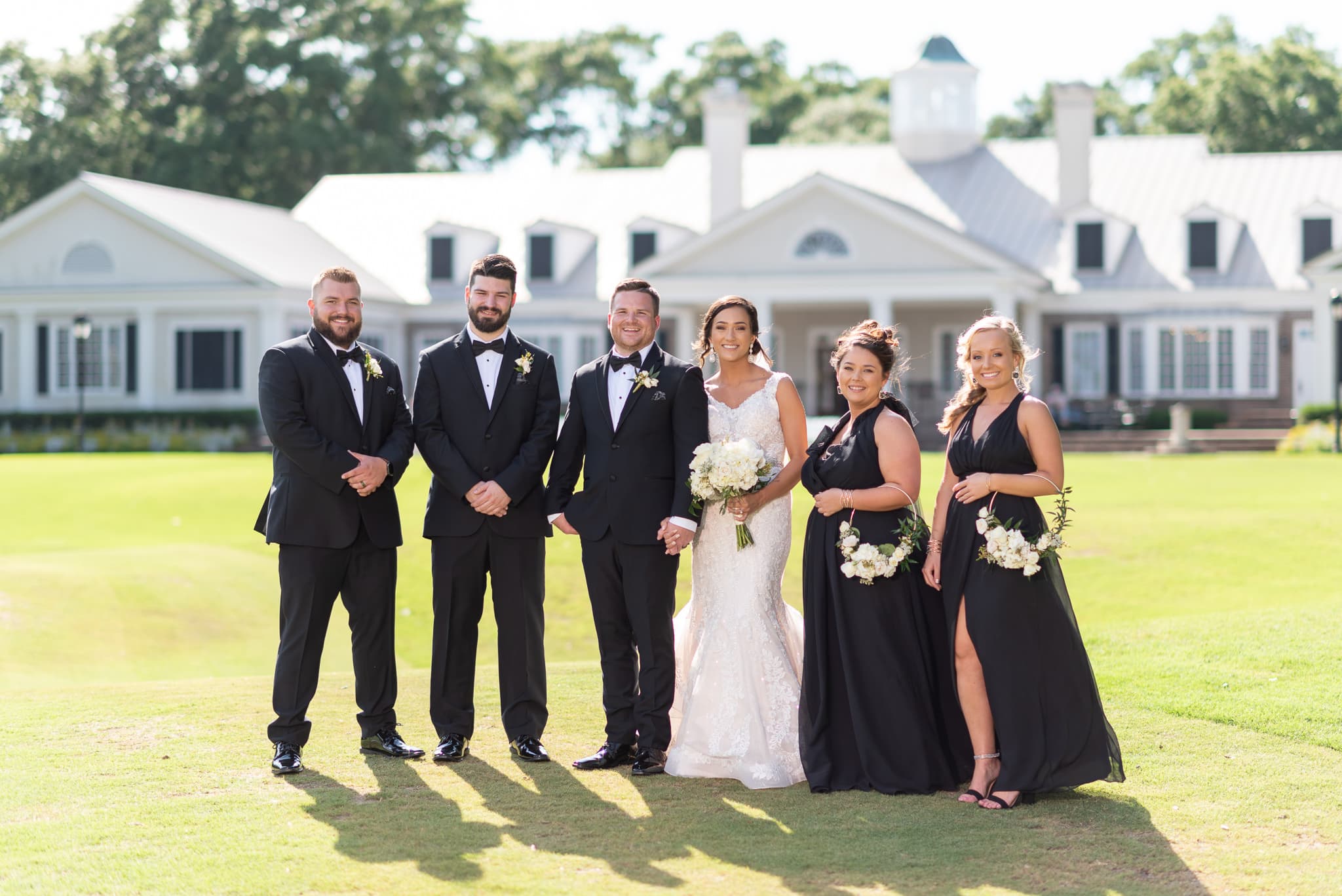 Bridal party with clubhouse in the background Pawleys Plantation