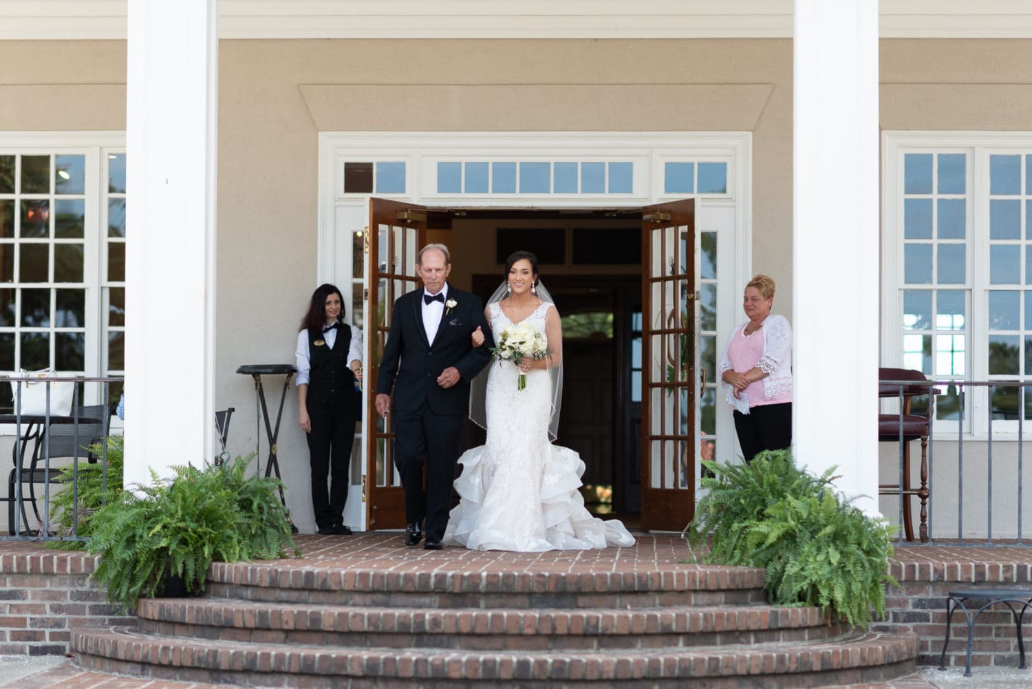 Bride and father walking from the back doors of the clubhouse Pawleys Plantation