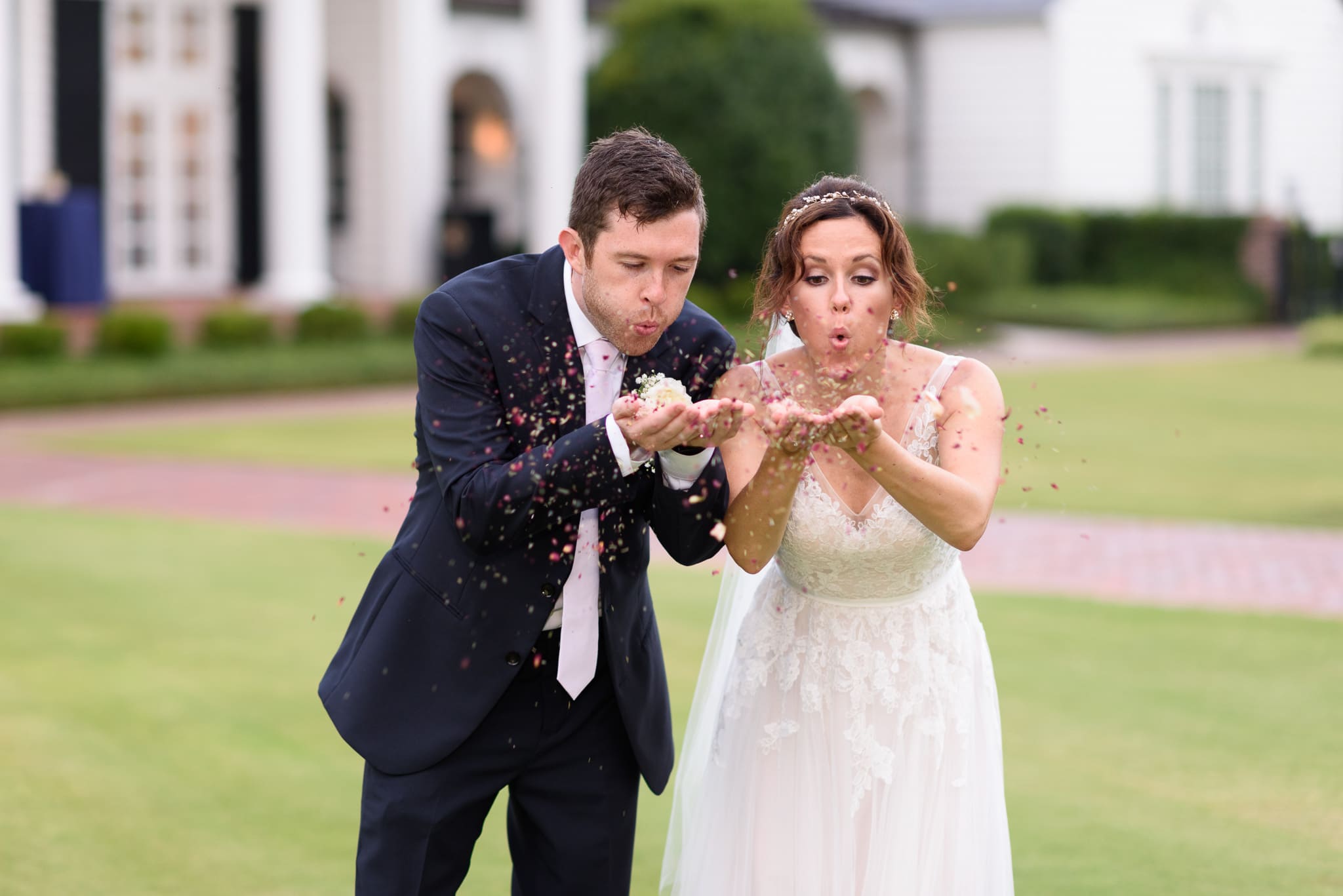 Bride and groom blowing flower petals Pine Lakes Country Club