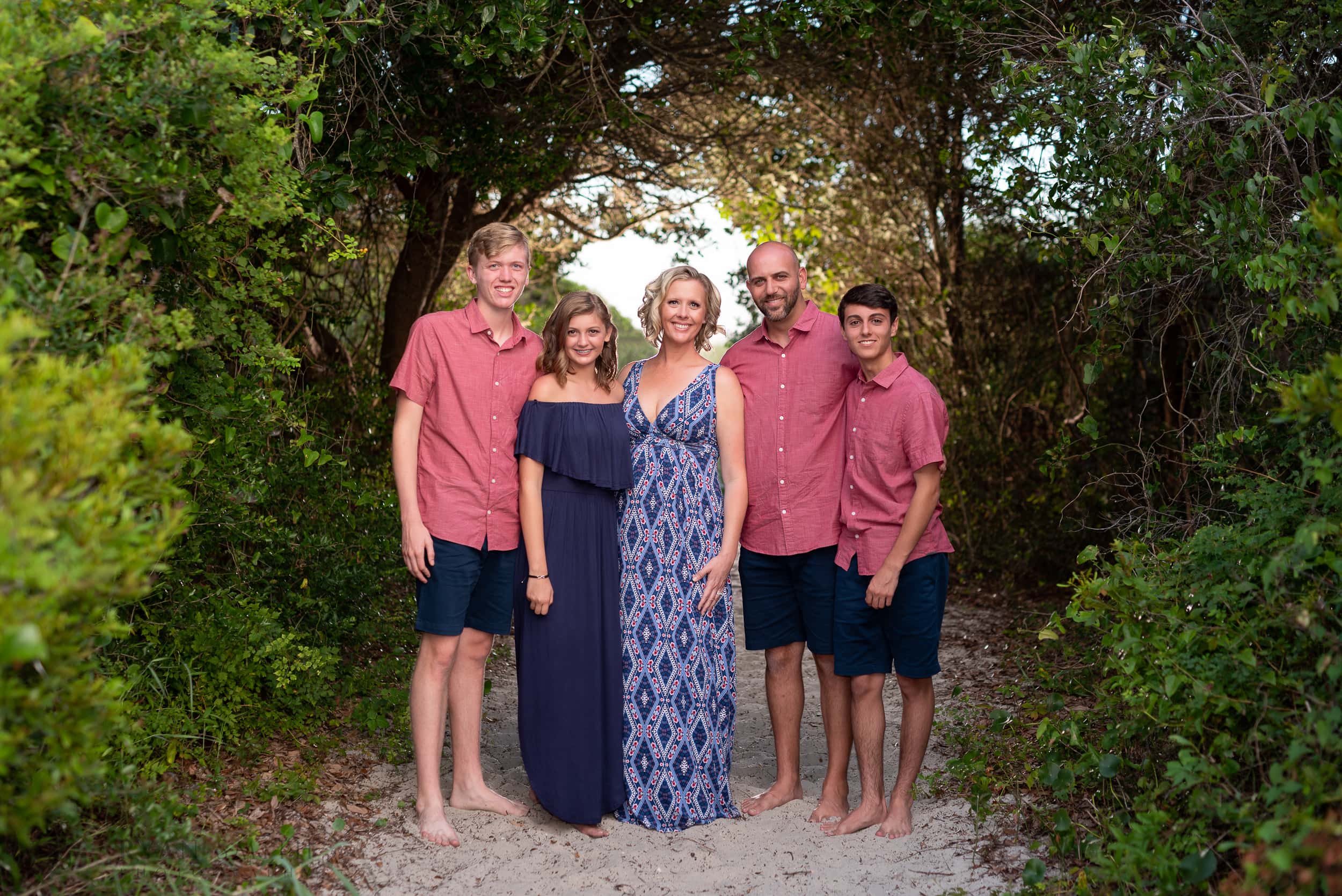 Family on the foliage covered walkway to the beach - Huntington Beach State Park
