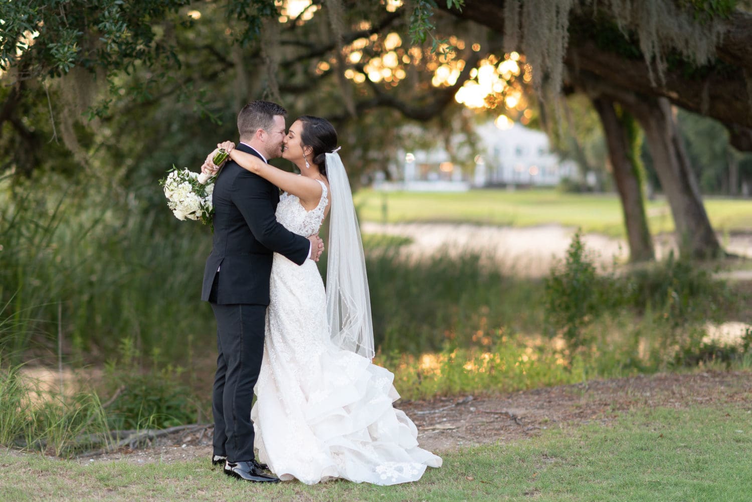 Great composition with bride and groom balanced by the sunset Pawleys Plantation