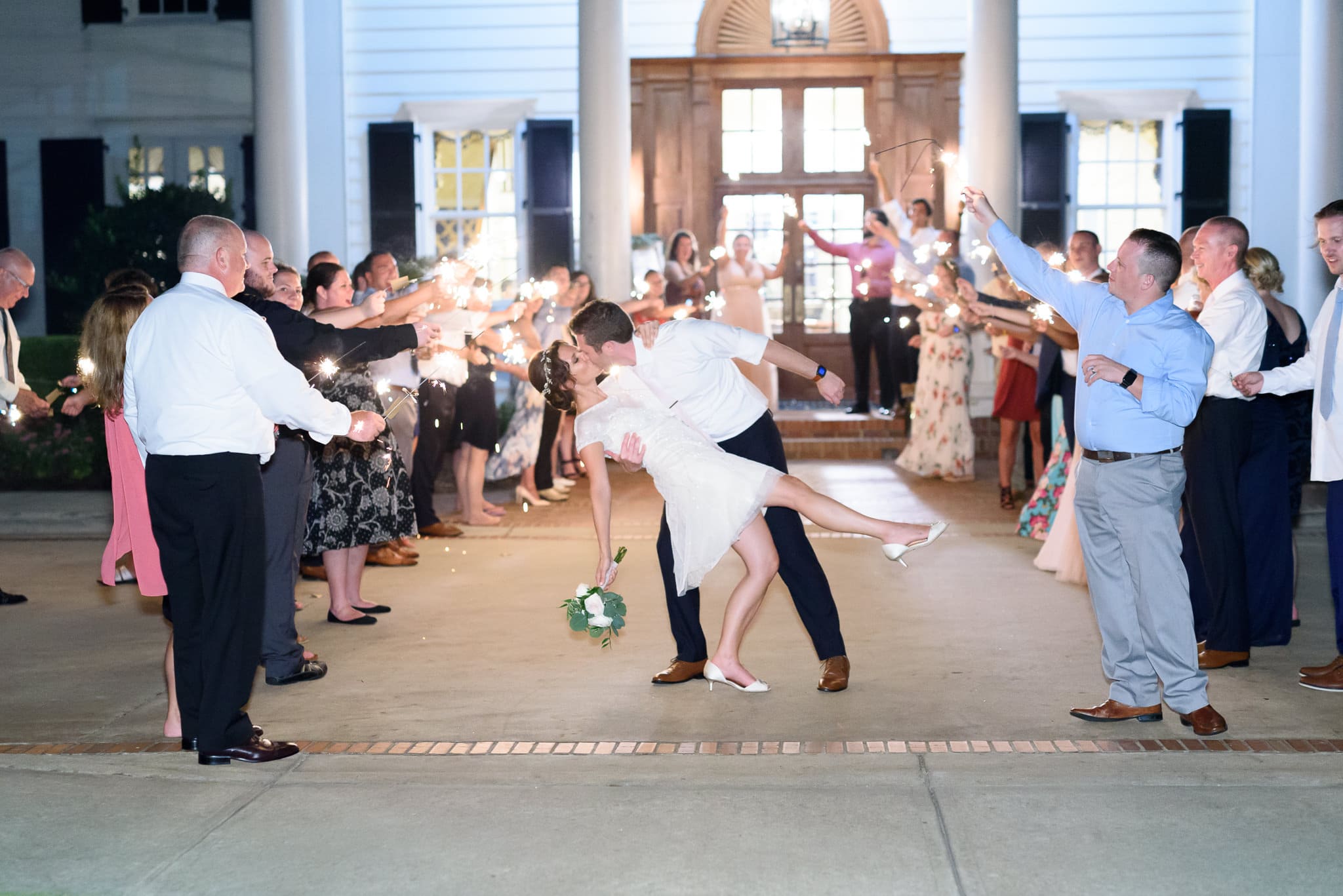Groom dipping back bride during sparkler exit Pine Lakes Country Club