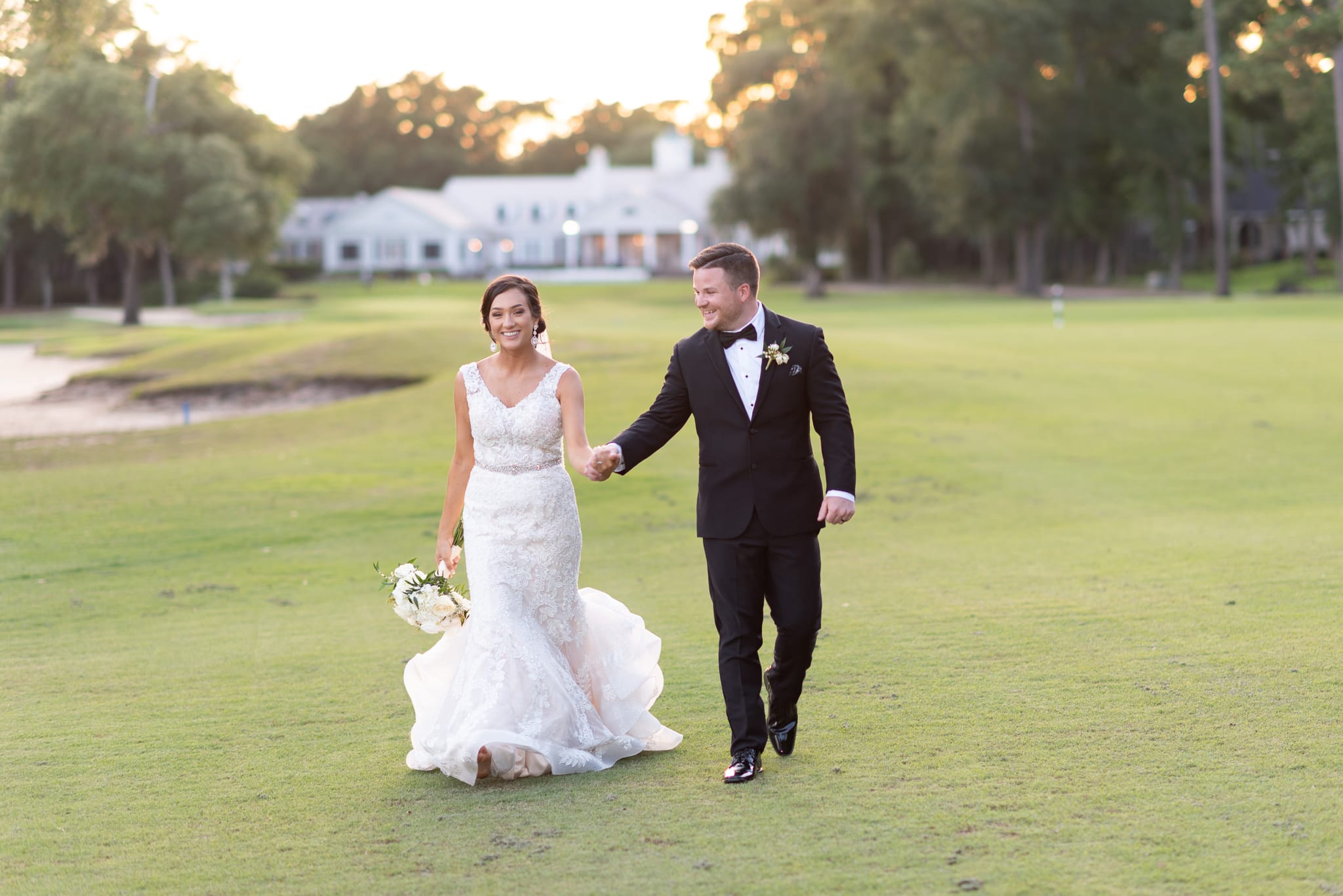 Holding hands walking down the golf course Pawleys Plantation