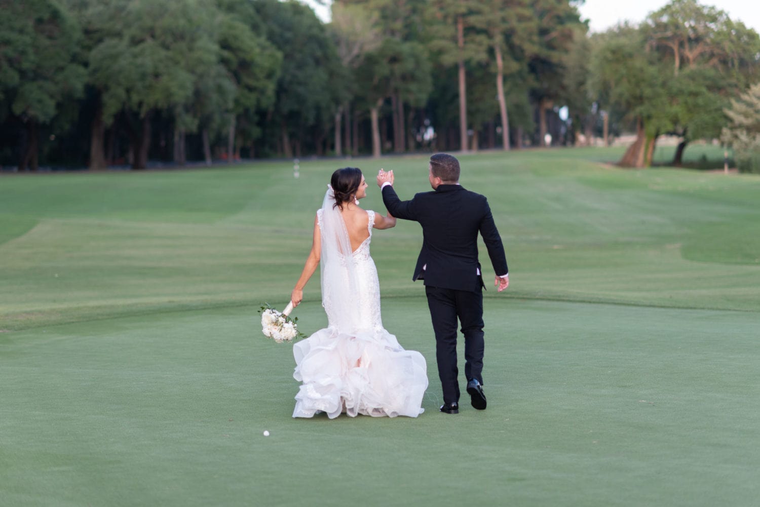 Walking down the golf course holding hands Pawleys Plantation
