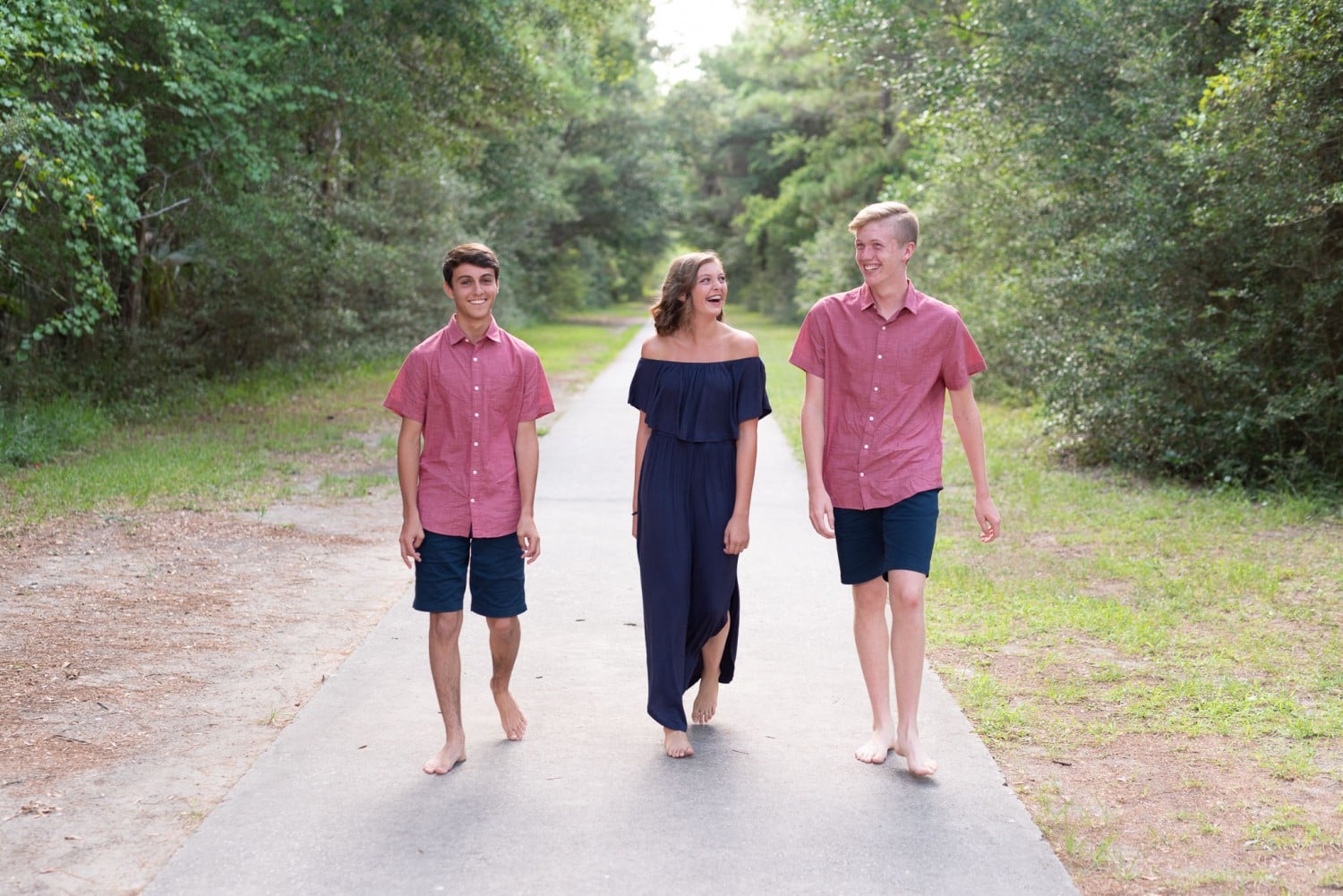 Brothers walking with sister down the path - Huntington Beach State Park