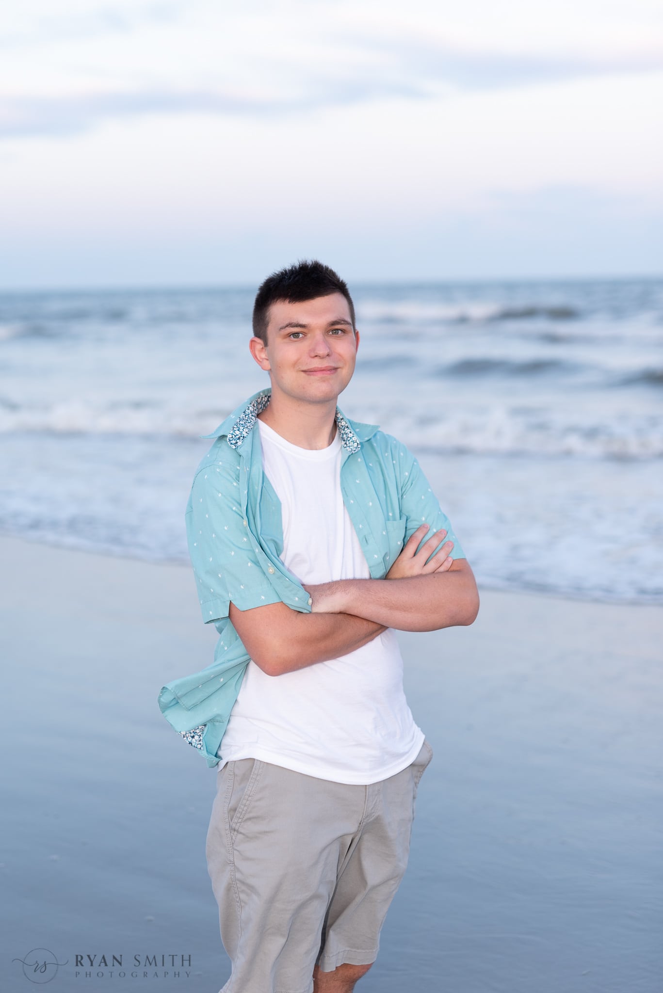 Young guy posting by the ocean -