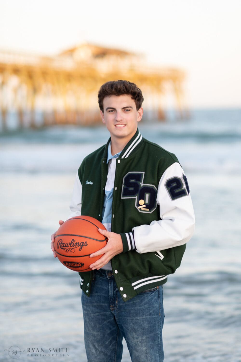 Senior portrait holding basketball in front of the pier - Myrtle Beach State Park