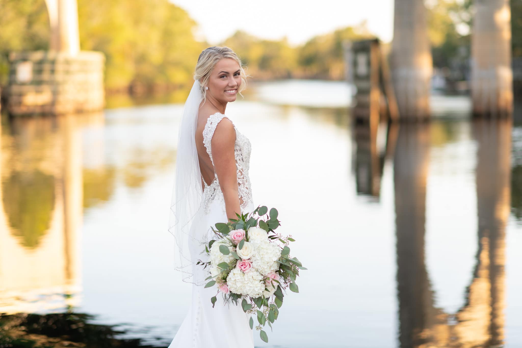 Bride looking back at the camera with the Waccamaw River in the background - Conway River Walk