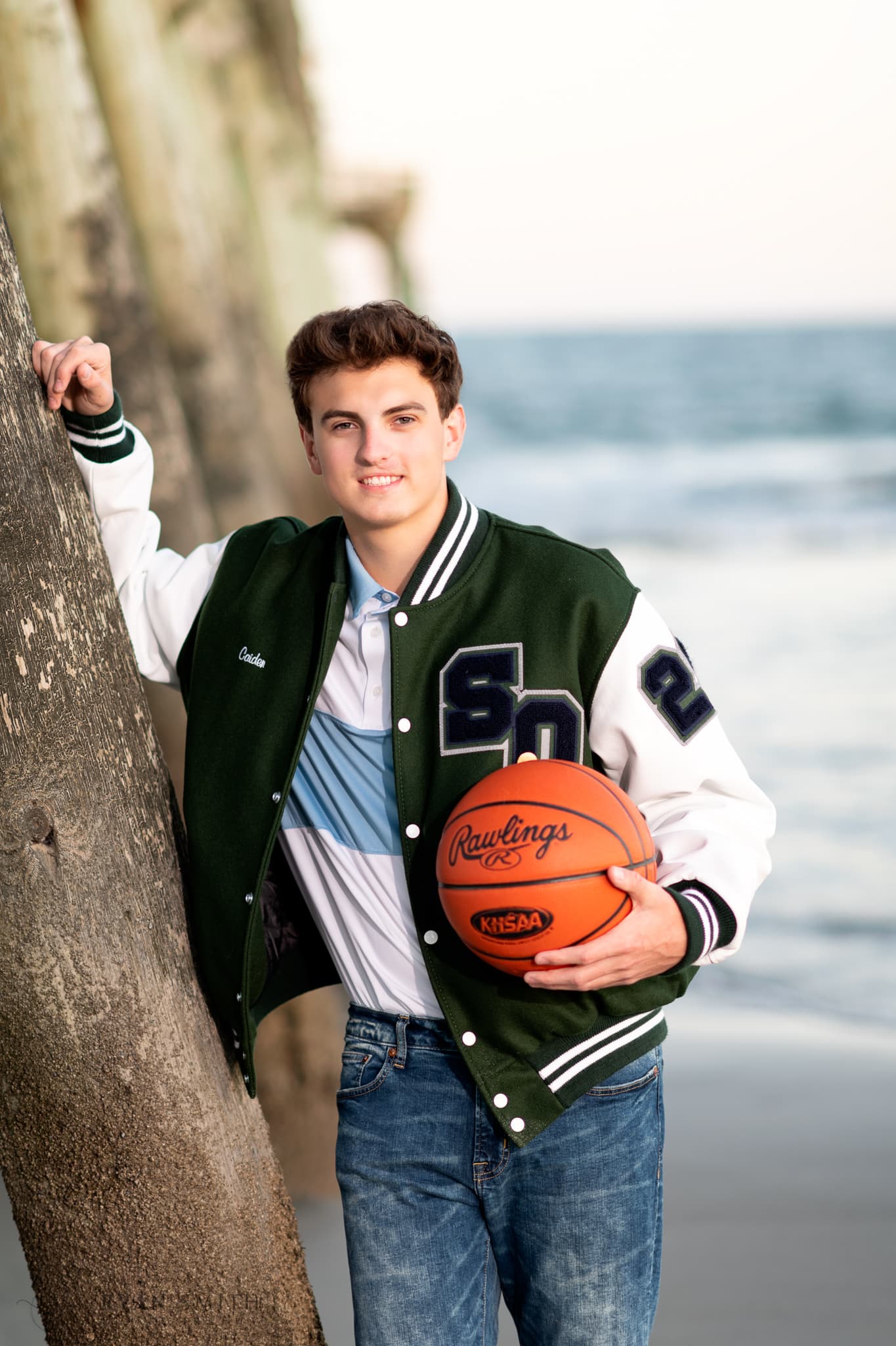 Senior boy holding basketball next to pier - Myrtle Beach State Park