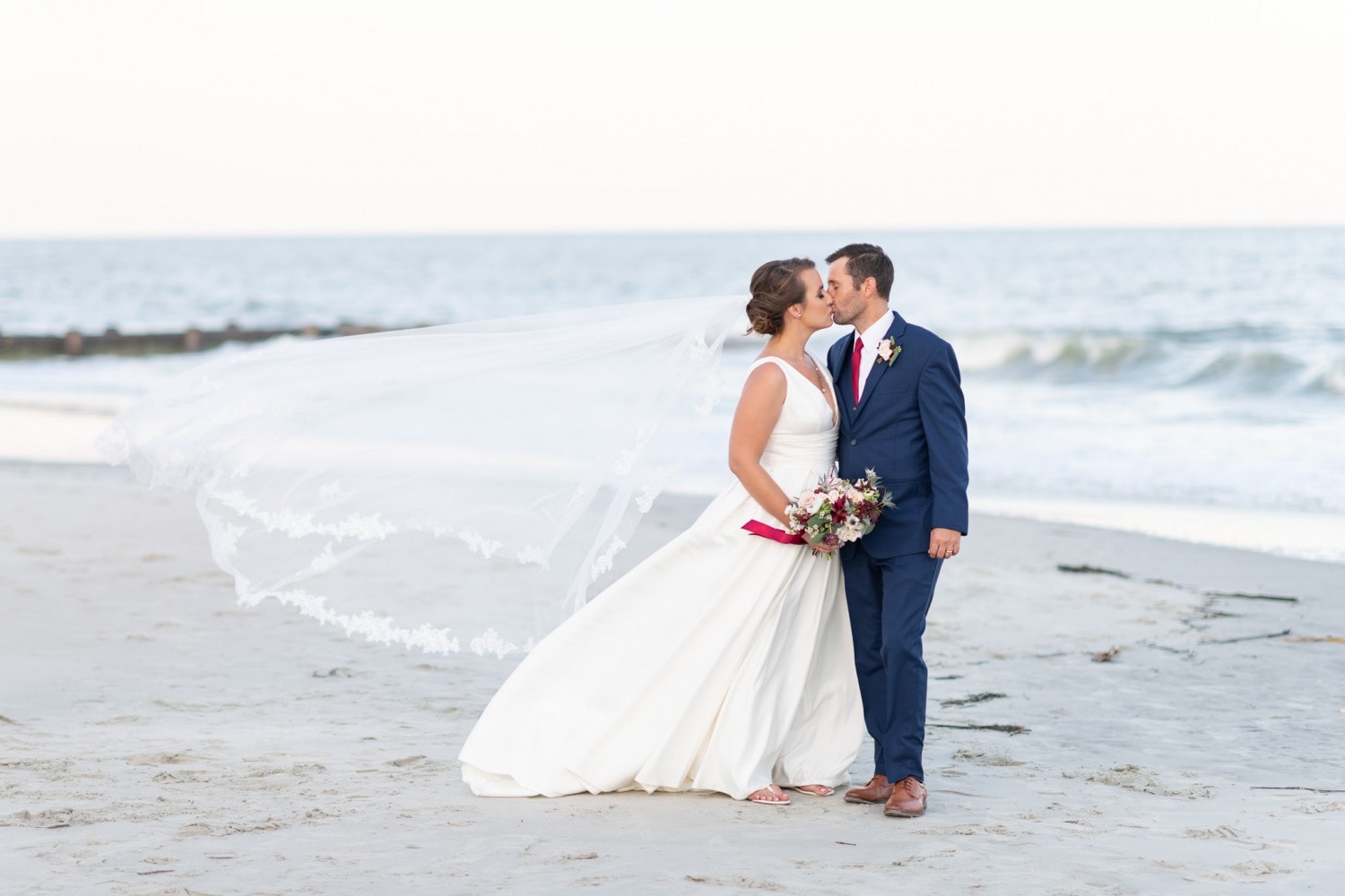 Bride and groom kissing with blowing veil - Pelican Inn - Pawleys Island