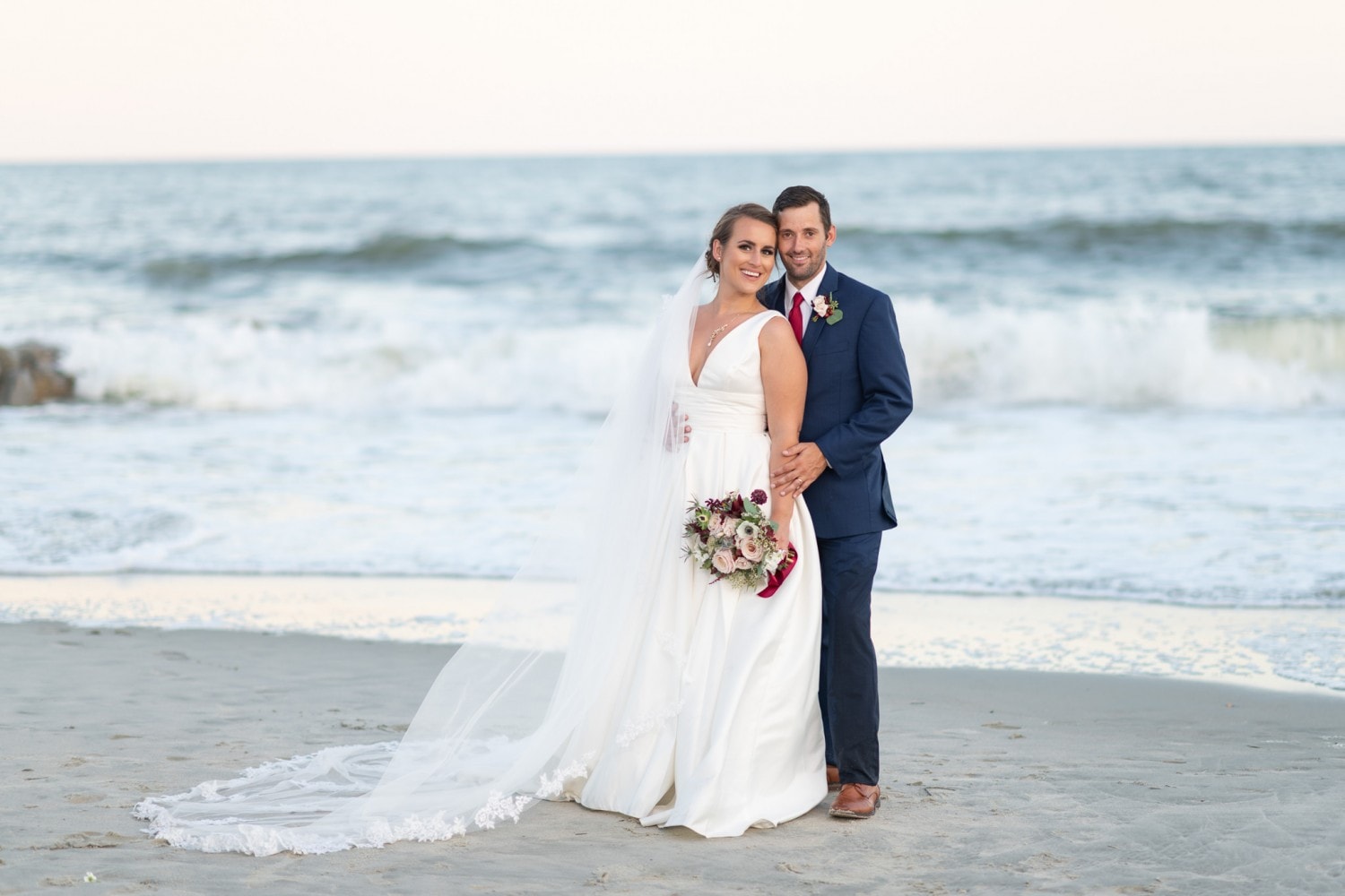 Bride and groom posing in front of the ocean together - Pelican Inn - Pawleys Island
