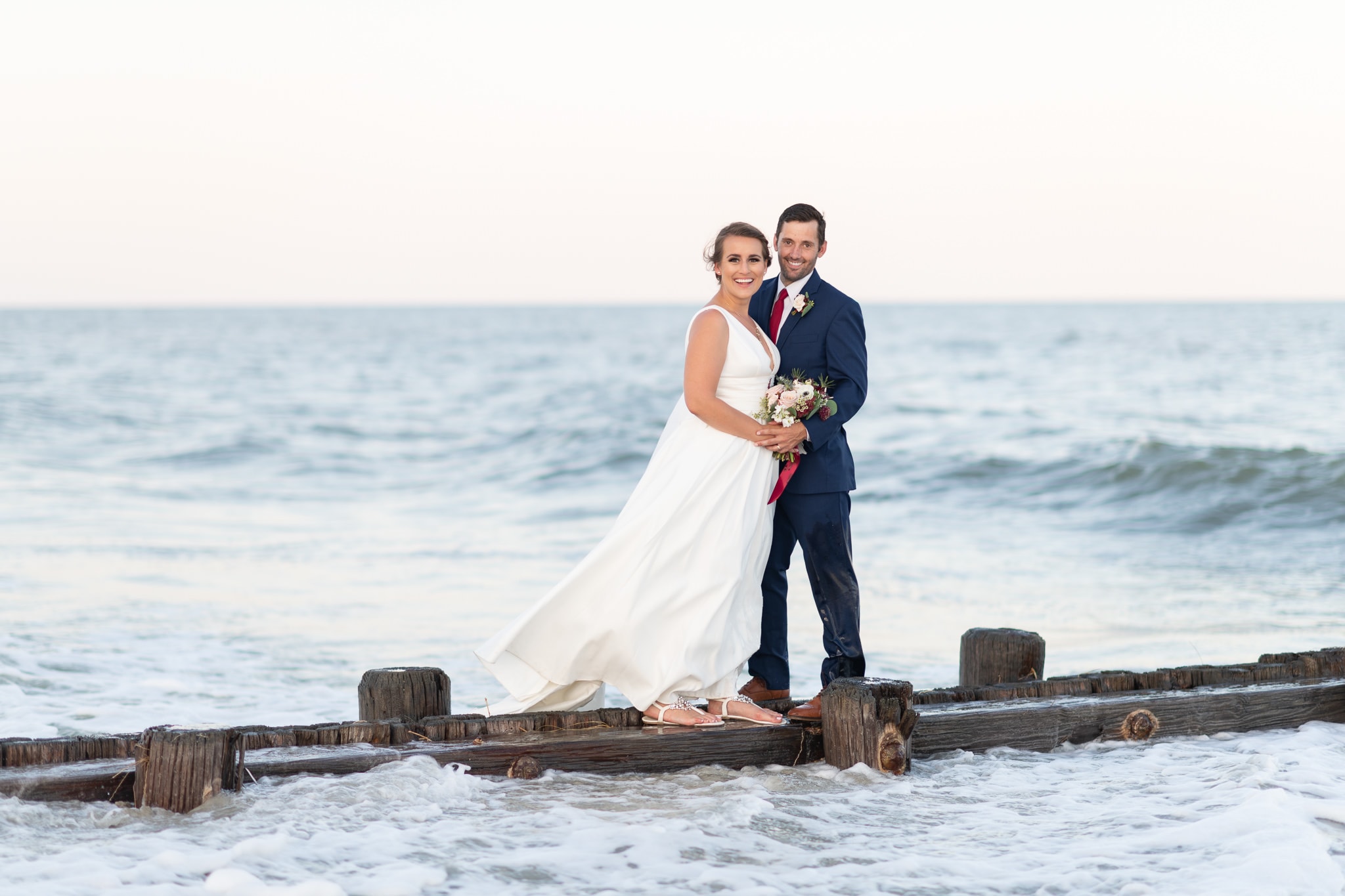 Bride and groom standing above the ocean - Pelican Inn - Pawleys Island