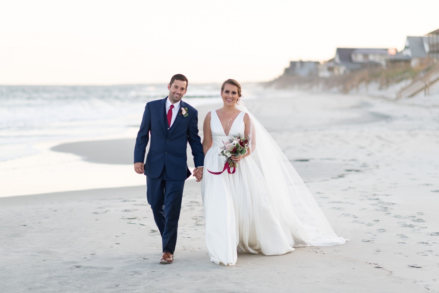Happy bride and groom walking down the beach - Pelican Inn - Pawleys Island