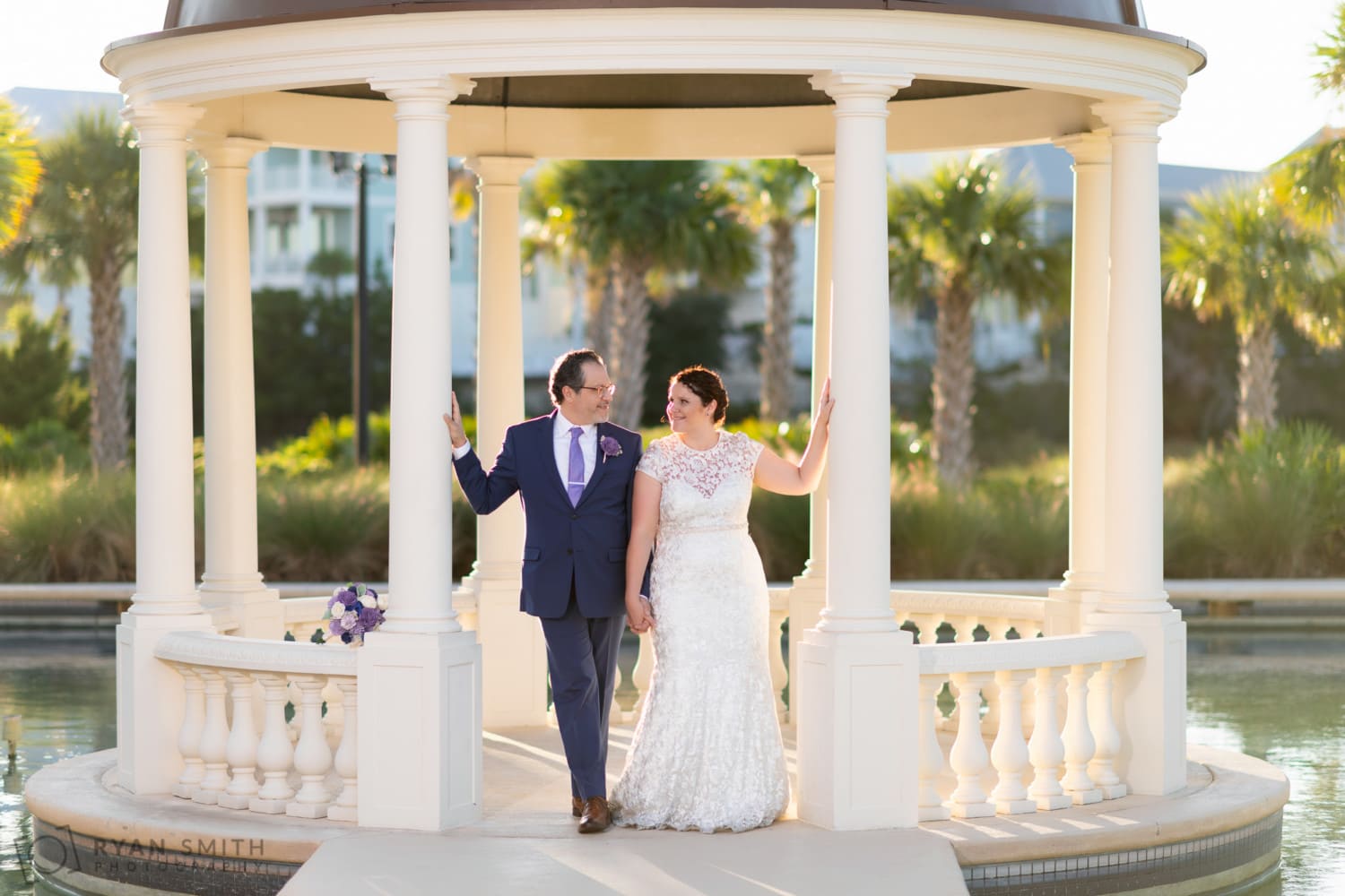 Bride and groom holding hands on the gazebo - North Beach Plantation
