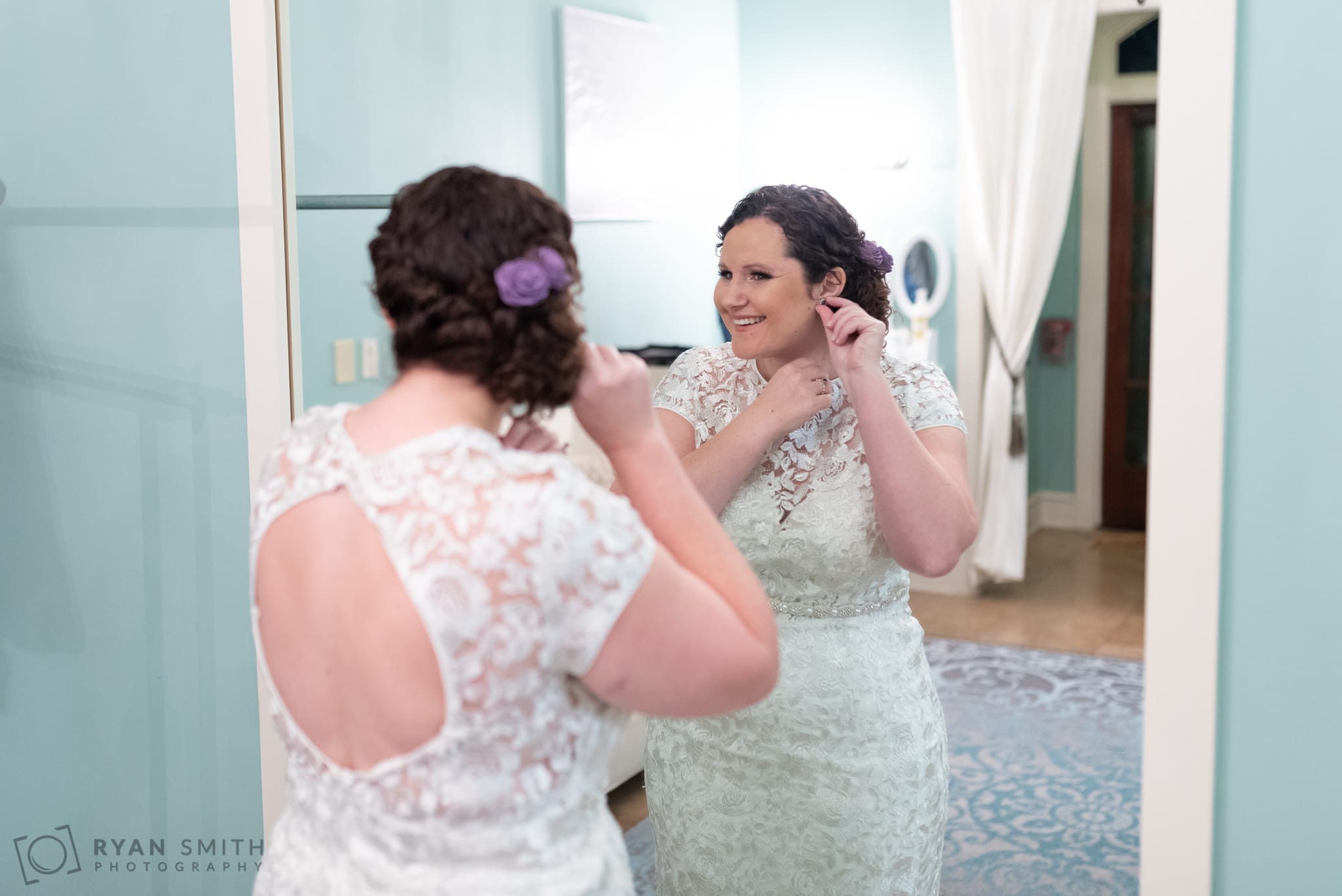 Bride putting on earrings in the mirror  - 21 Main Events