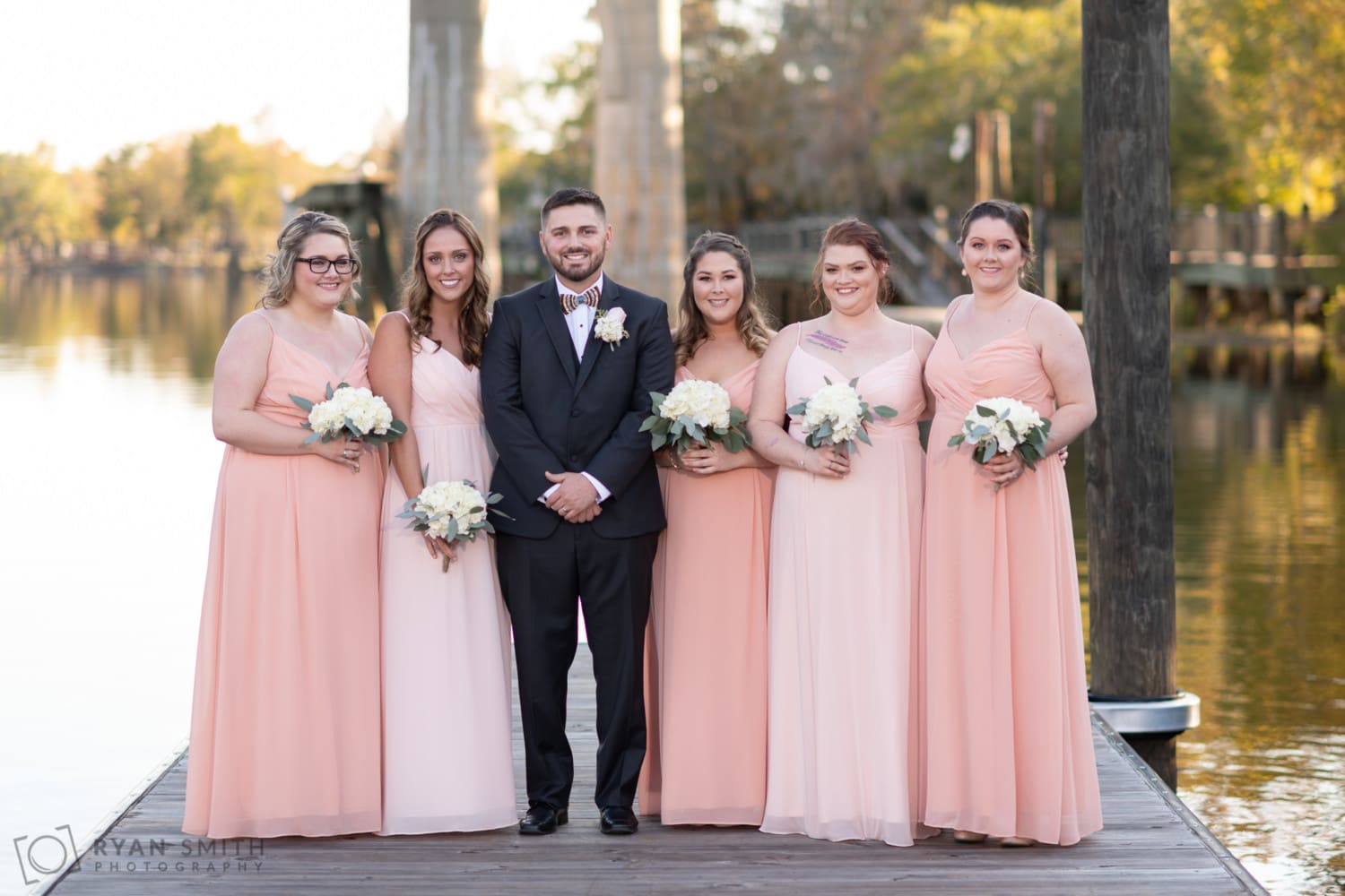 Groom standing with the bridesmaids - Conway River Walk