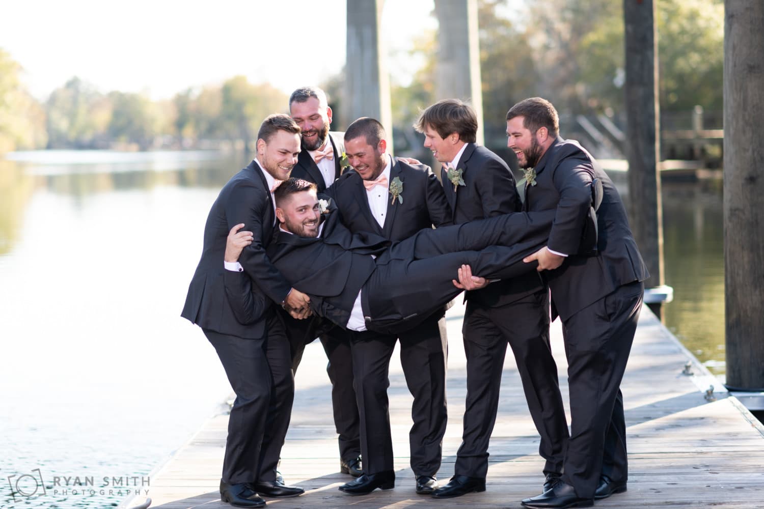Groomsmen throwing groom in the river - Conway River Walk