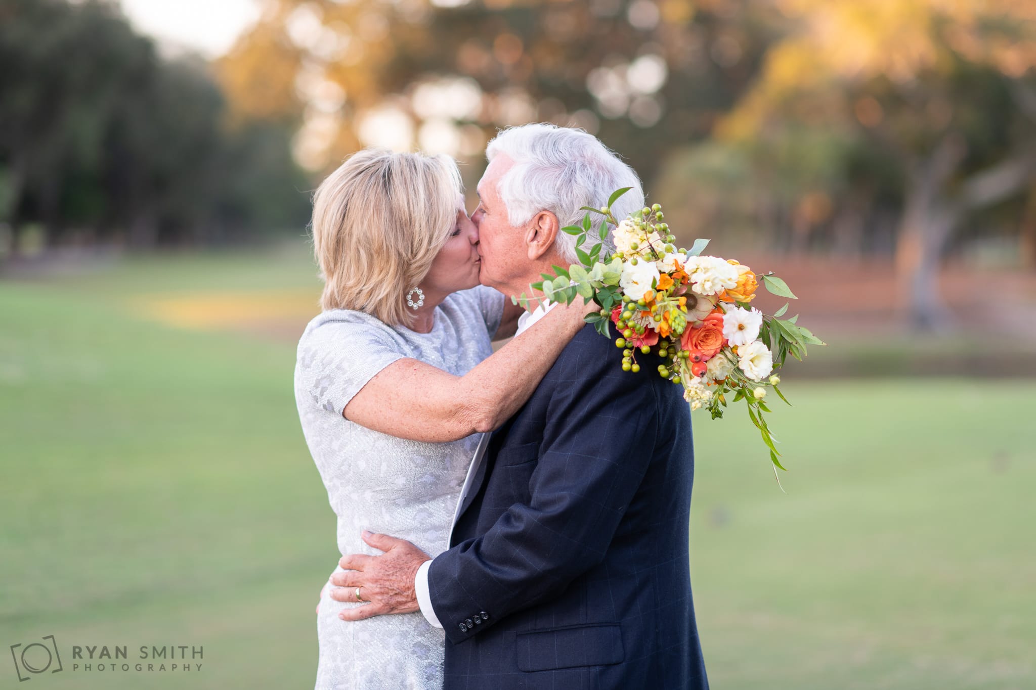 Kiss with bride's arms and flowers around the grooms shoulders - Dunes Golf and Beach Club - Myrtle Beach