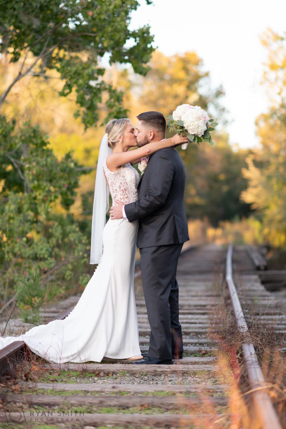 Low angle on train tracks of bride and groom - Conway River Walk