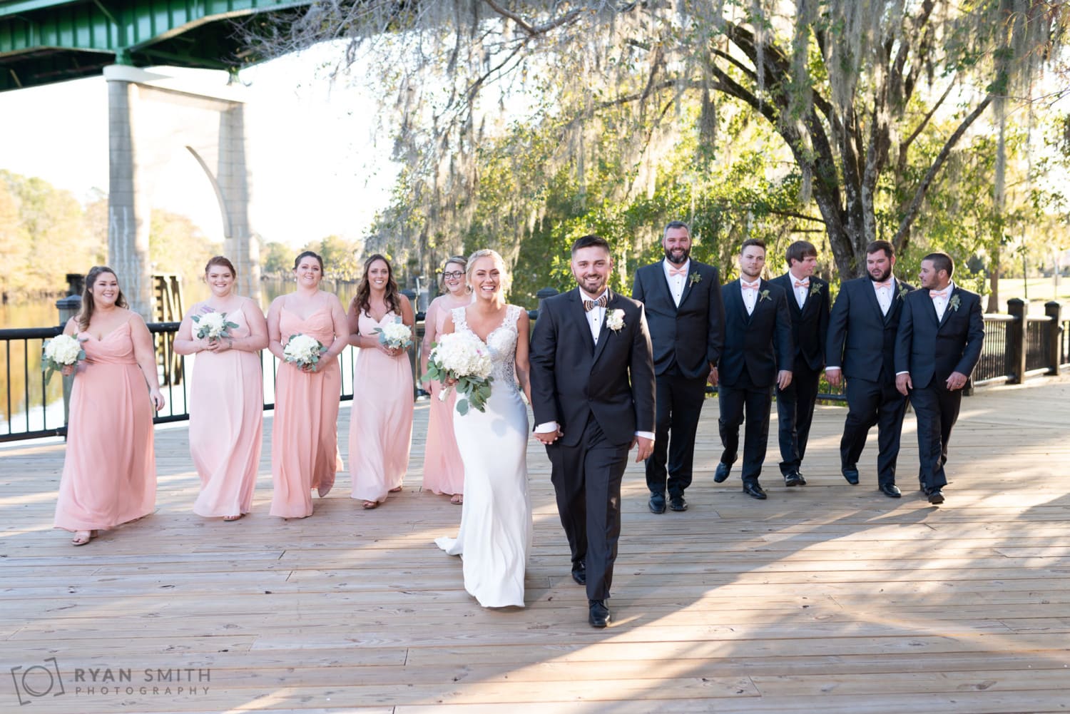 Wedding party walking towards the camera - Conway River Walk