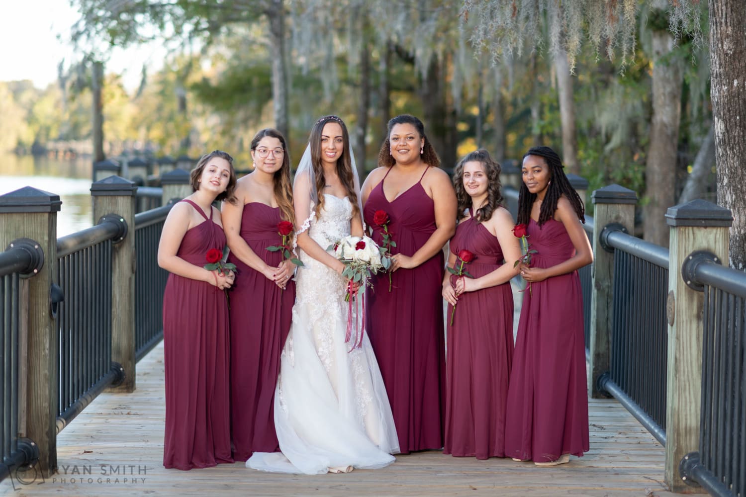 Bridal party portrait with bridesmaids holding a rose - Conway River Walk