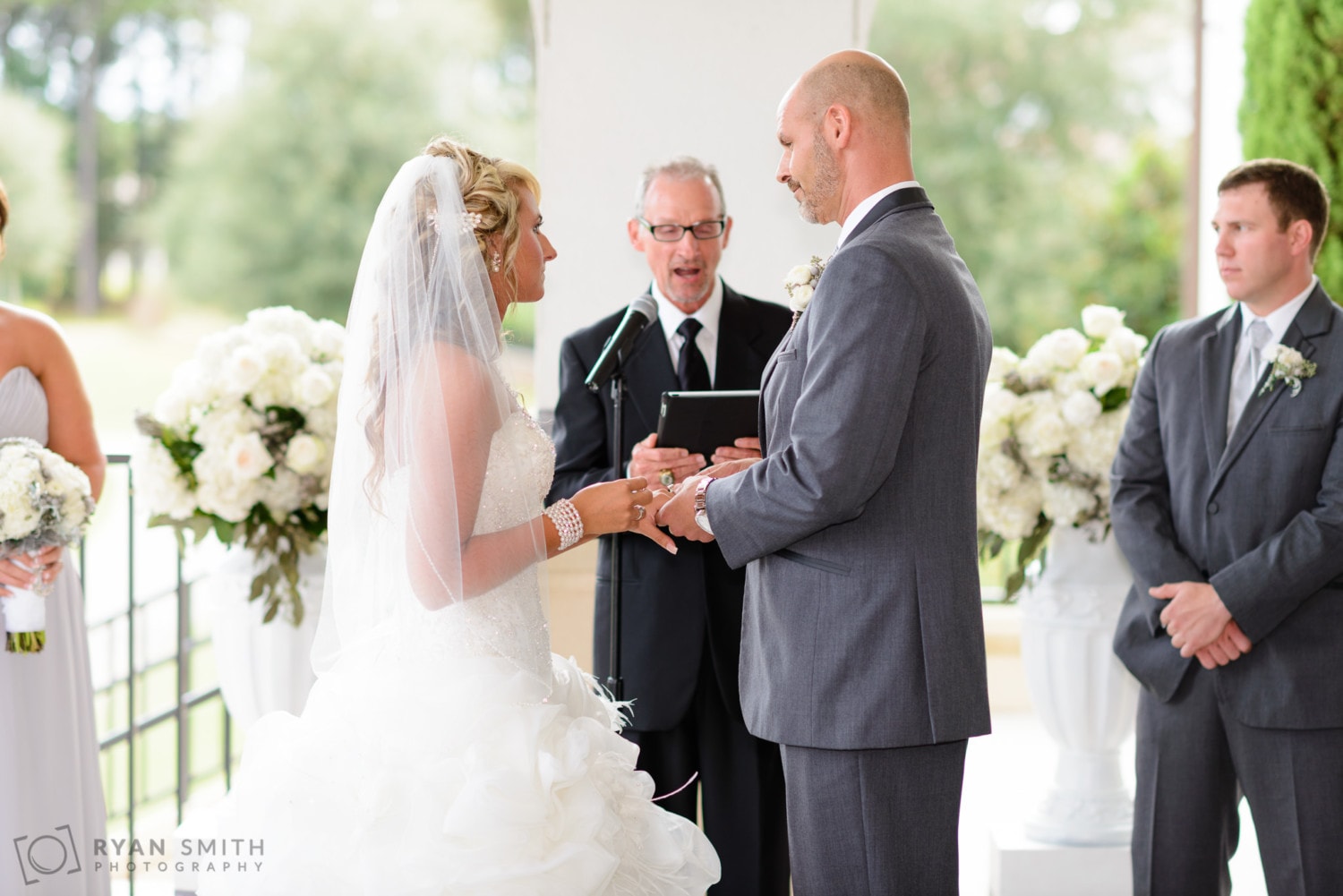 Bride and groom exchanging rings - Members Club at Grande Dunes