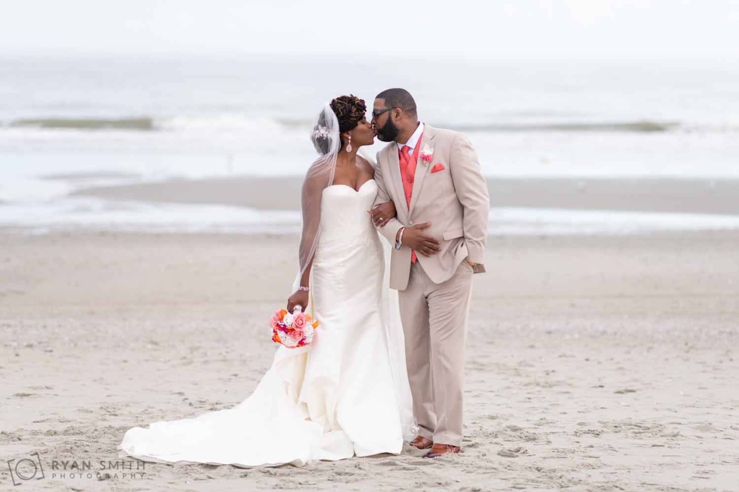 Bride and groom kissing in front of the ocean - Doubletree Resort - Myrtle Beach