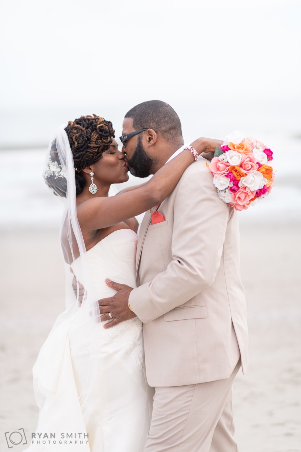Bride kissing groom with flowers around his neck - Doubletree Resort - Myrtle Beach
