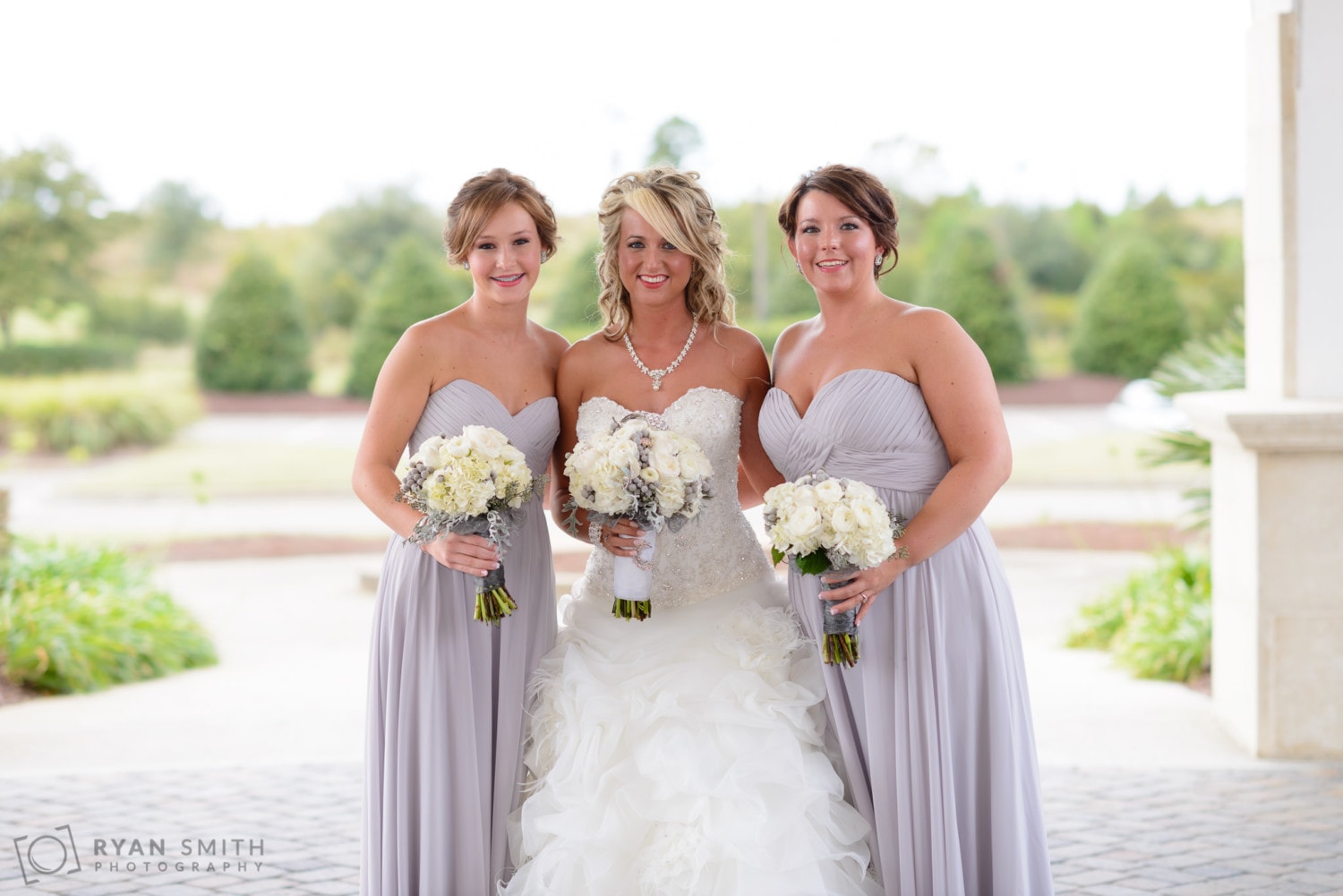 Bride with bridesmaids in front of the clubhouse - Members Club at Grande Dunes