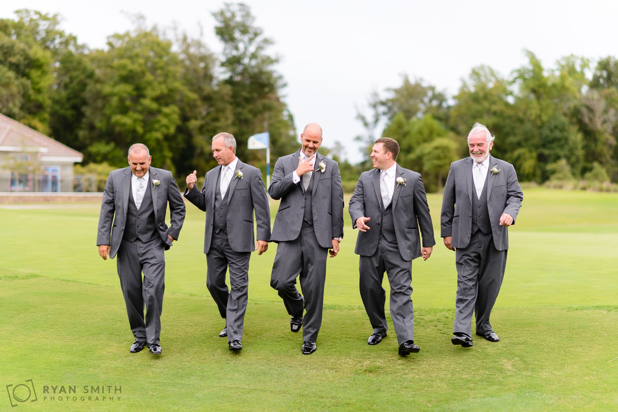 Groomsmen walking down the golf course - Members Club at Grande Dunes