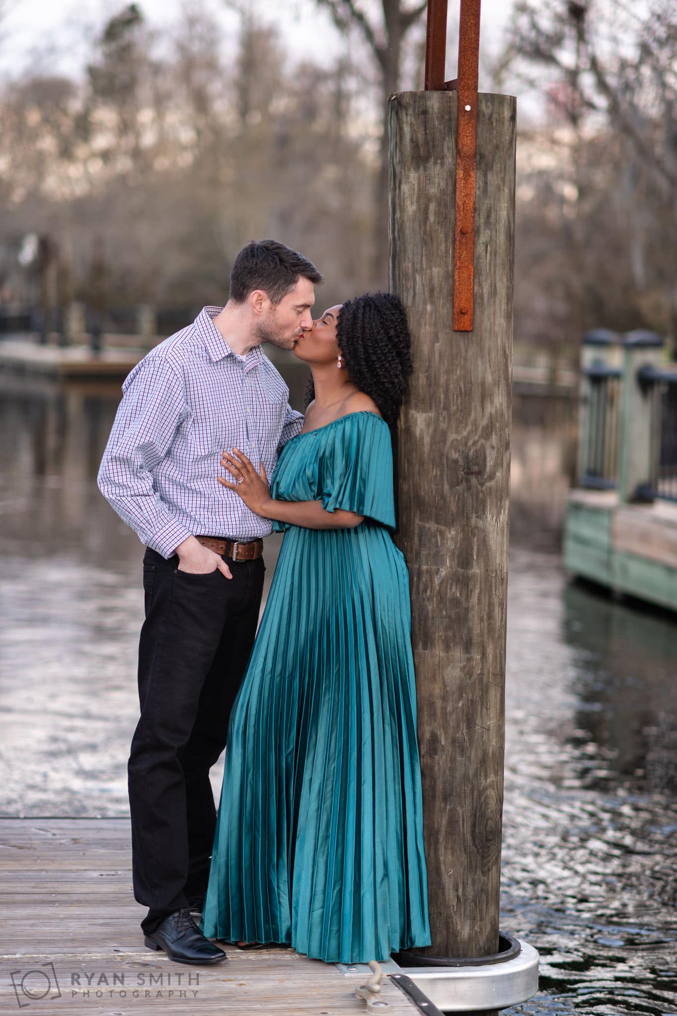 Anniversary portraits leaning against the river dock - Conway Riverwalk